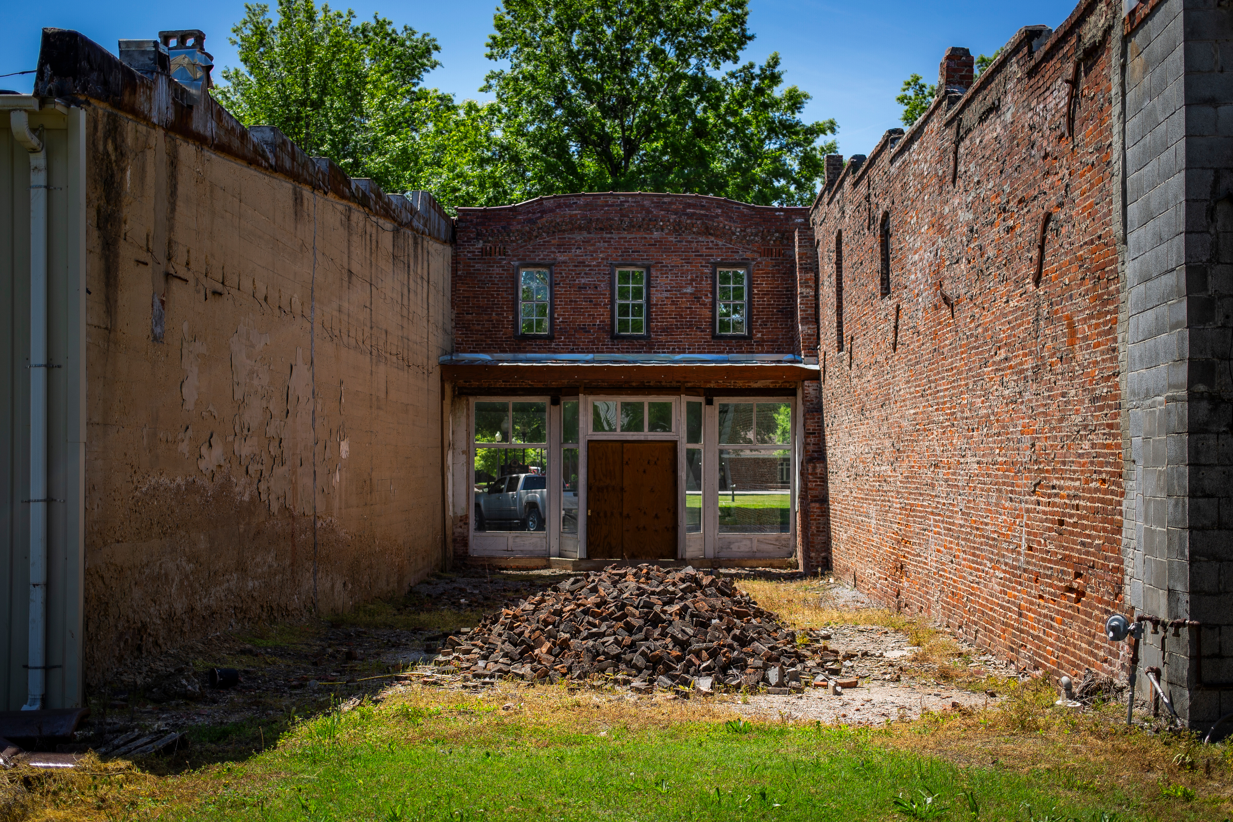 A facade and pile of bricks from a building facing the town square of Courtland, Ala. Damage to manufacturing jobs from a sharp acceleration in globalization since the turn of the century has contributed to the city’s economic decline. (The New York Times)