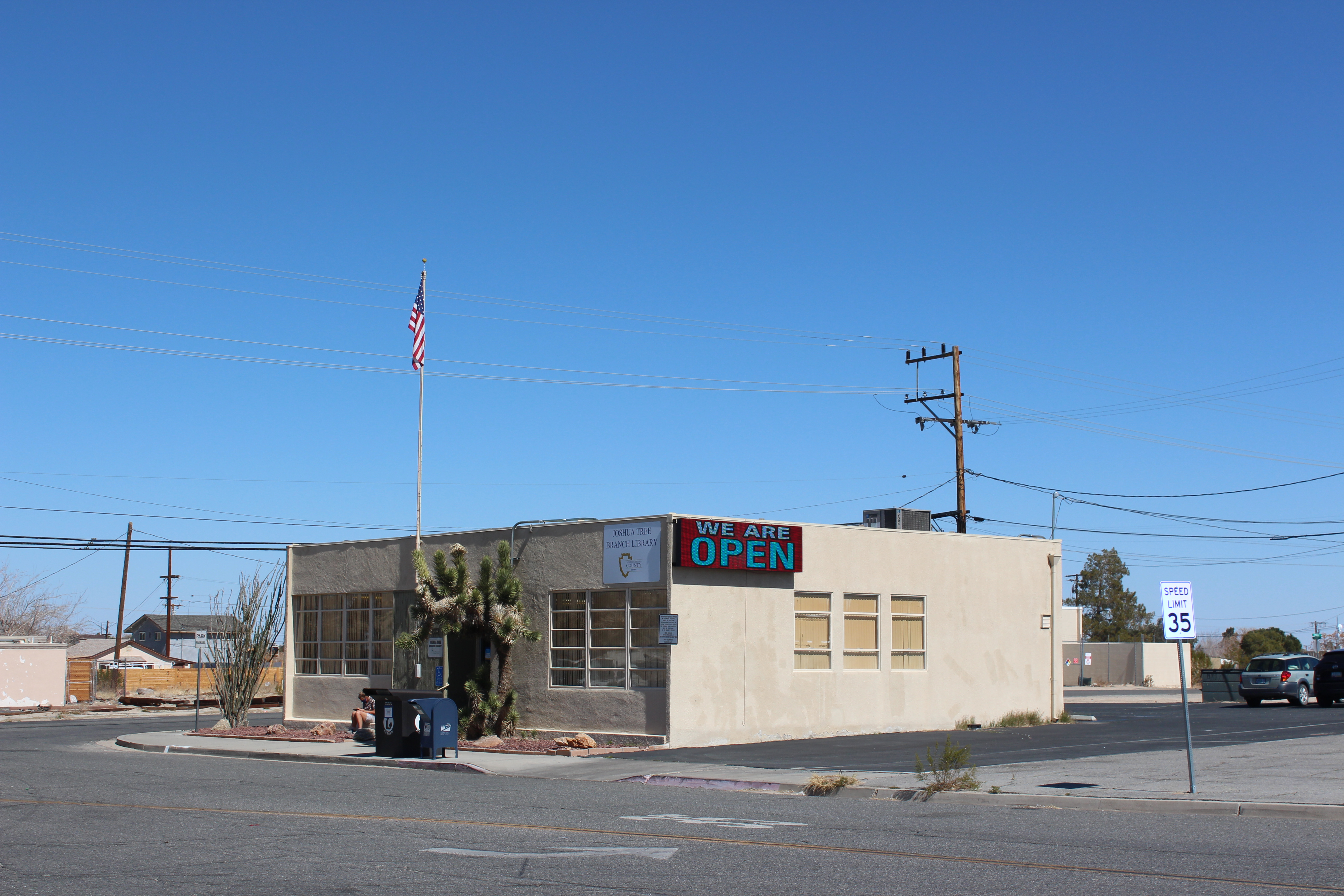 Corner shot of library with digital sign reading "WE ARE OPEN"