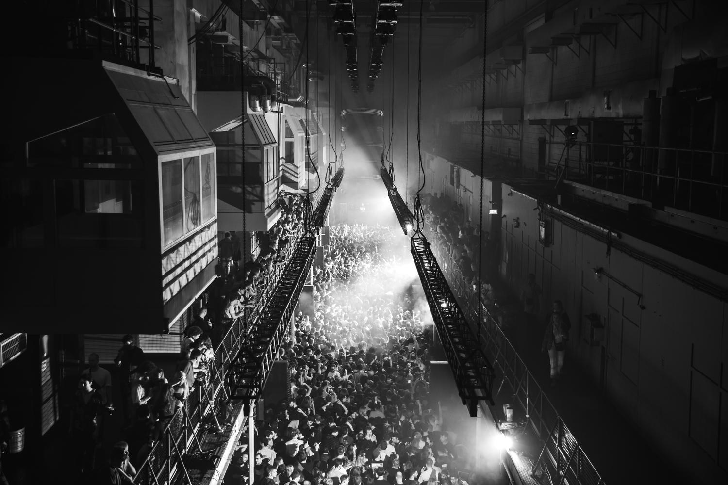 Crowd packed inside Printworks London during AVA Club night under monochrome lighting.