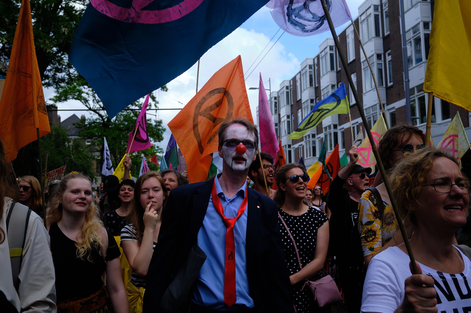 Philippe-Sarfati-reportage-photography-photographer-street-documentary-photojournalism-photojournalist-xr-extinction-rebellion-rotterdam-netherlands-sad-clown-colorful-flags-tie-corporate