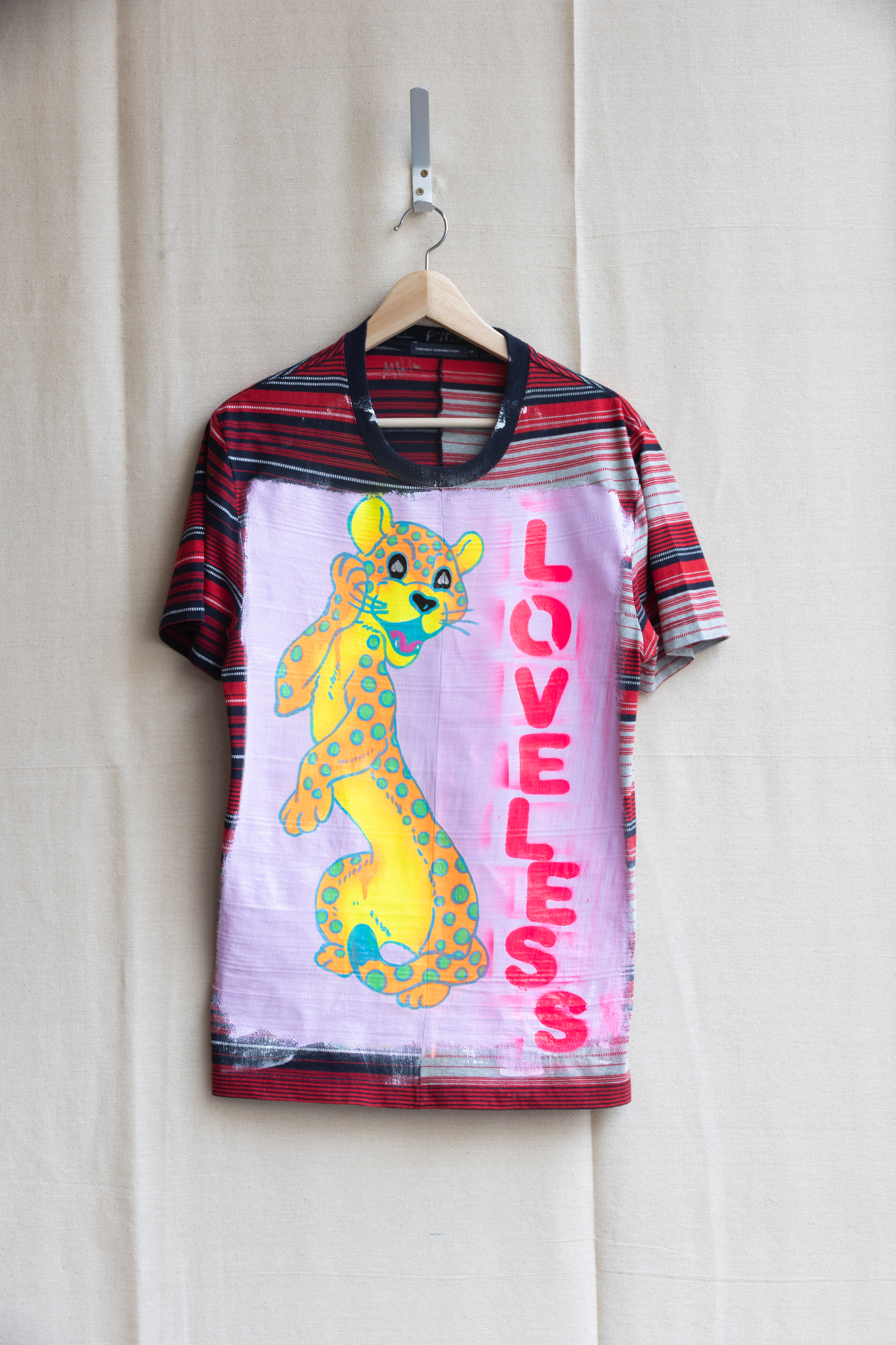 Michael Pybus LOVE LESS (Never Changes its Spots) Acrylic, flashe, chrome ink & oil based spray paint, finished with archival high gloss on artist’s used cotton T-shirt. 2023