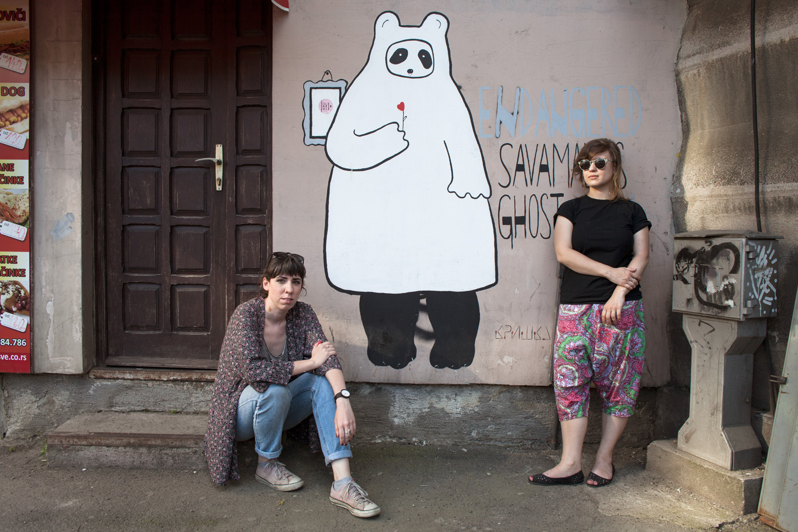 The writers Barbara Dimic and Tijana Tripkovic posing in front of one of their graffiti in Savamala district