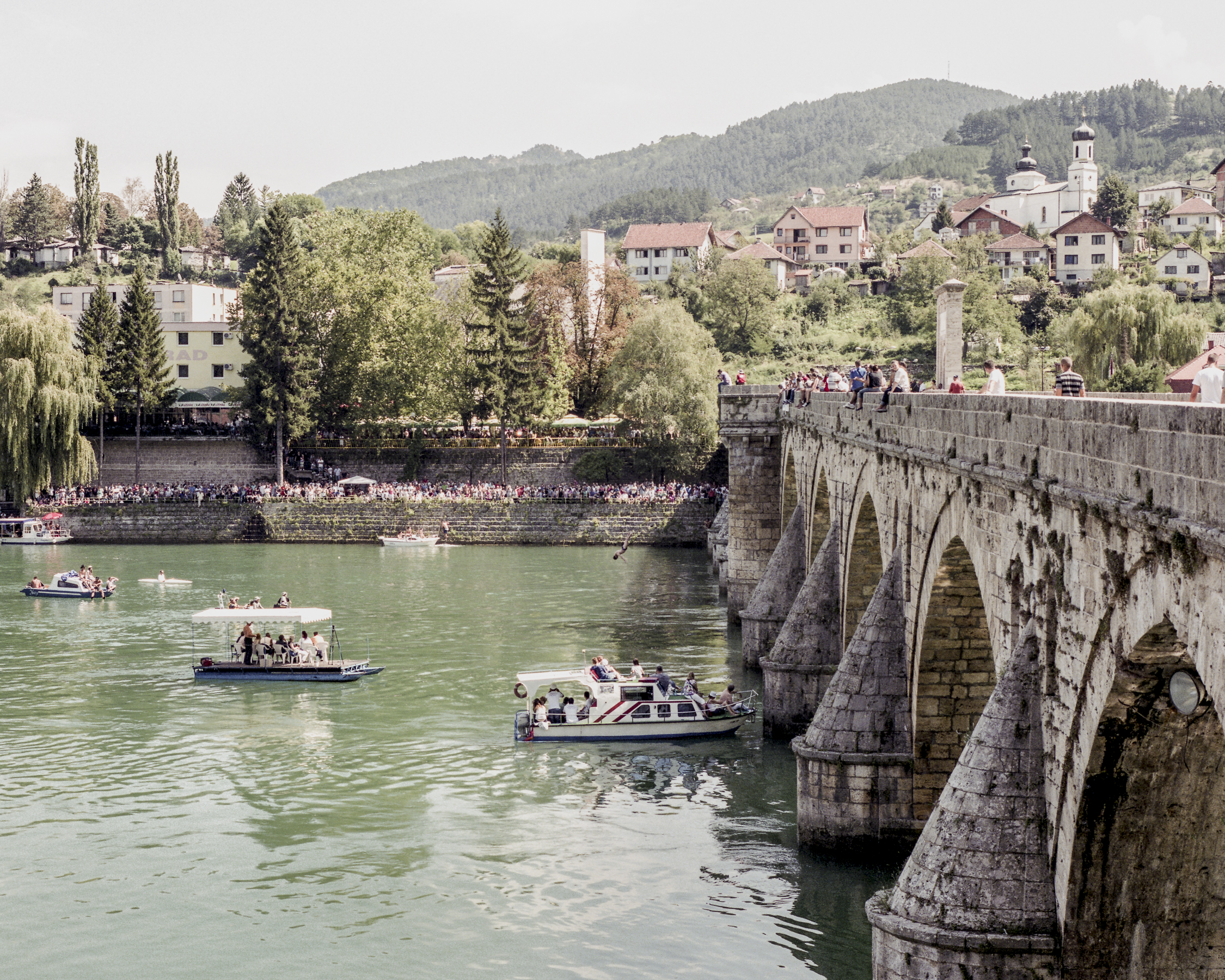 Titular bridge on the Drina from Ivo Andric novel, Old Bridge in Visegrad, pictured during muncipal water jumping contest. Old Bridge was used to execute civilians in the presence of other city inhabitants – people were killed by having their throats slit, or thrown to the water and being shot at.