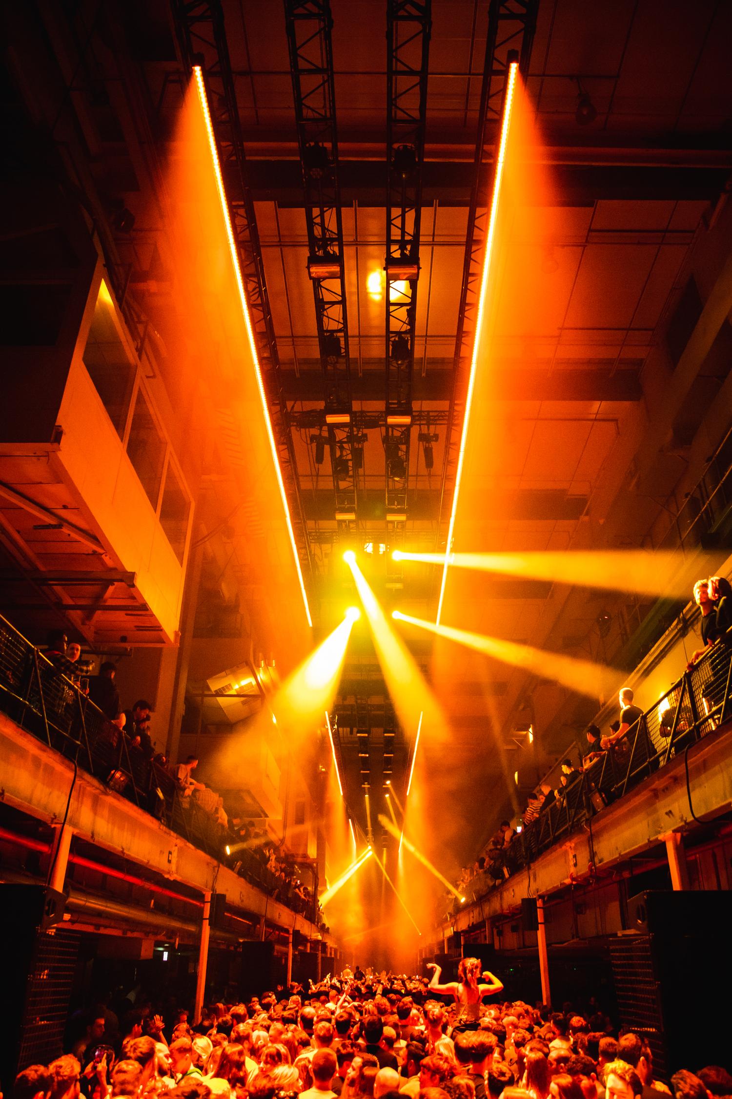Orange lighting beams over crowd at Printworks London during AVA Club night.