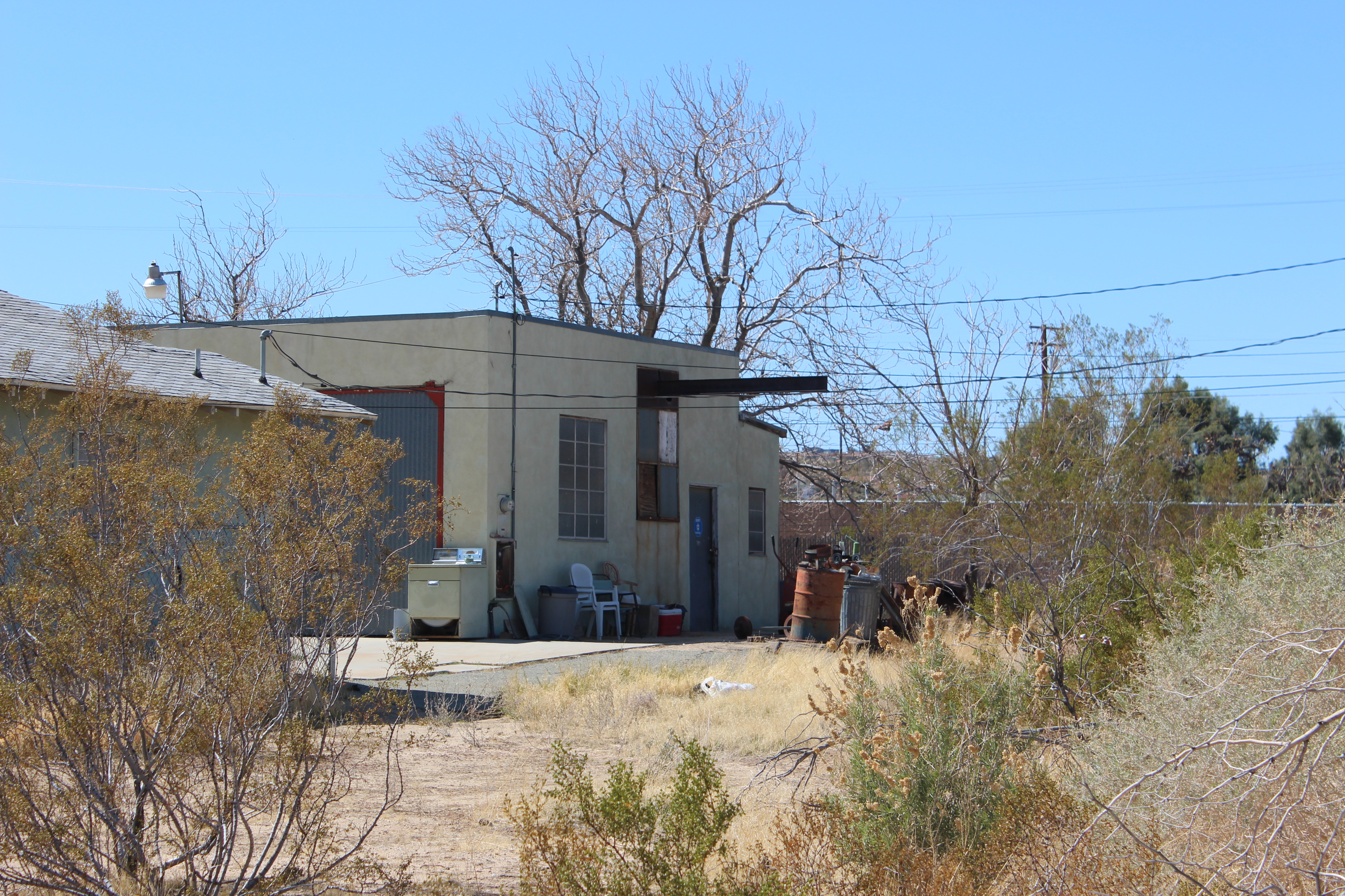 Someone's backyard garage featuring grid-grilled windows, light green paint, deep red trim