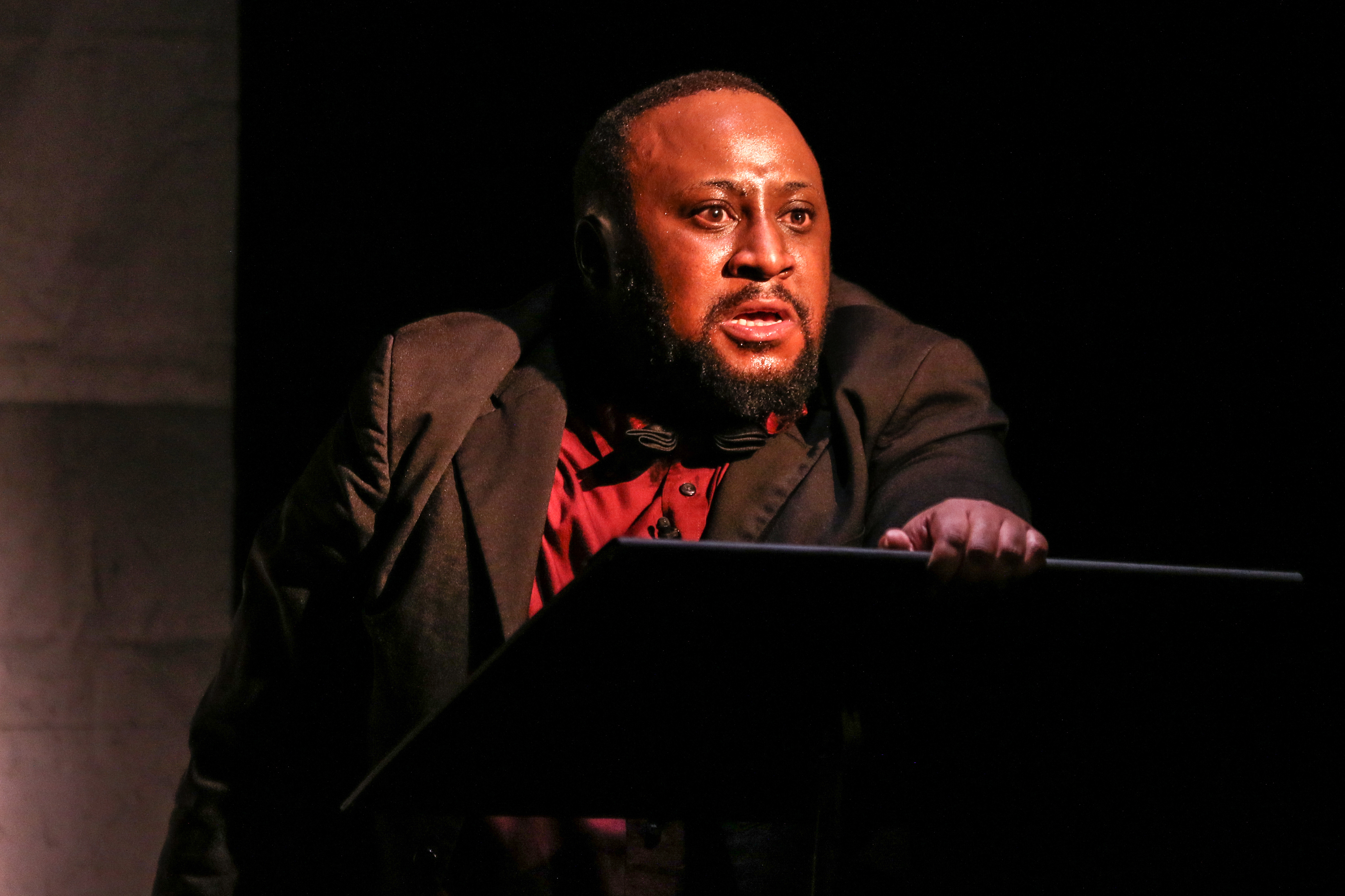 The same man staring angrily from behind a lectern.