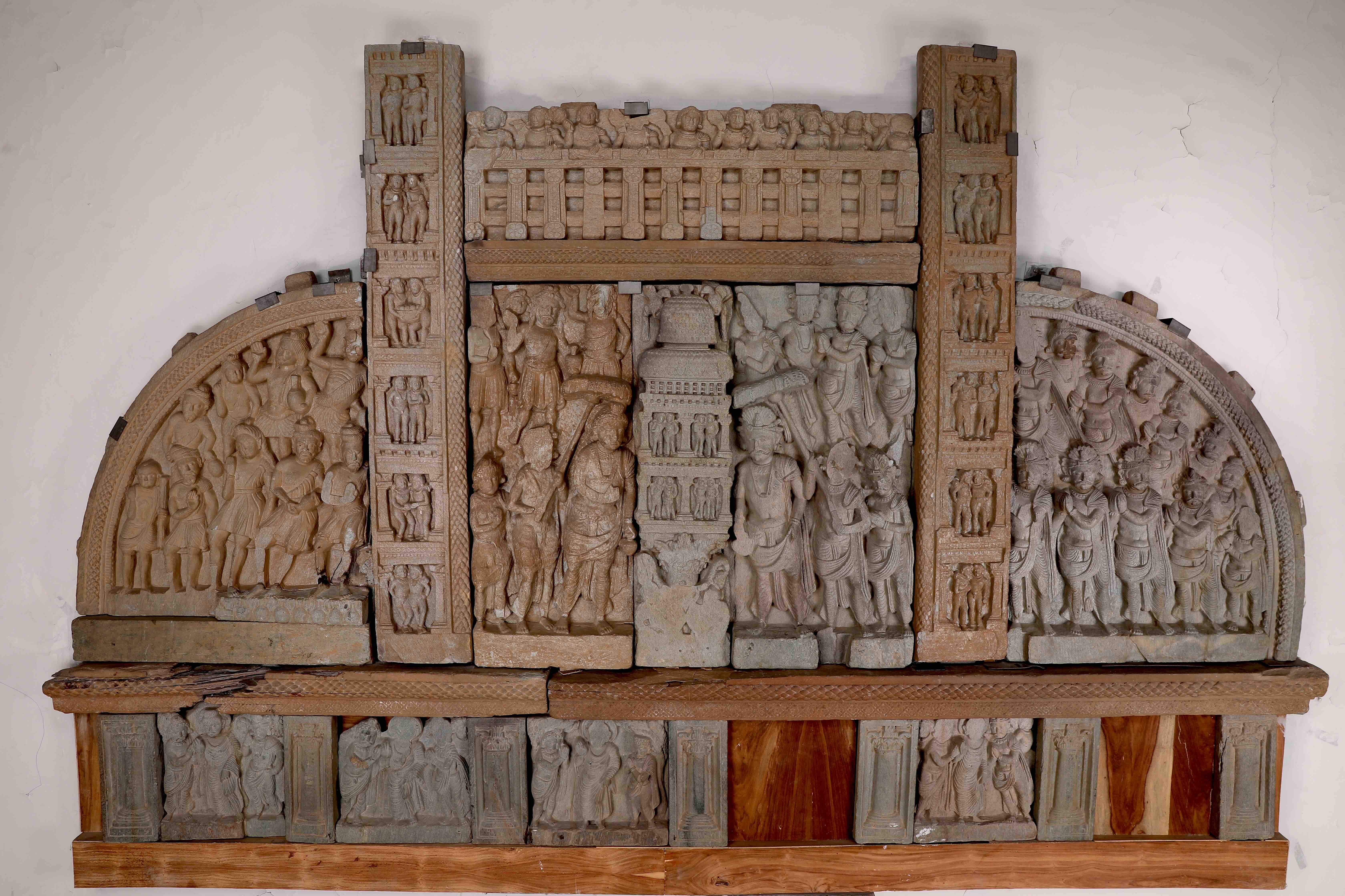 Zar Dheri SteleThis impressive gateway, comprised of 18 intricately carved pieces, once formed the upper section of an entrance to a Buddhist complex. The panel depicts a dynamic society of 91 figures, with the central scene featuring two royal figures worshipping a stupa.Material: Schist