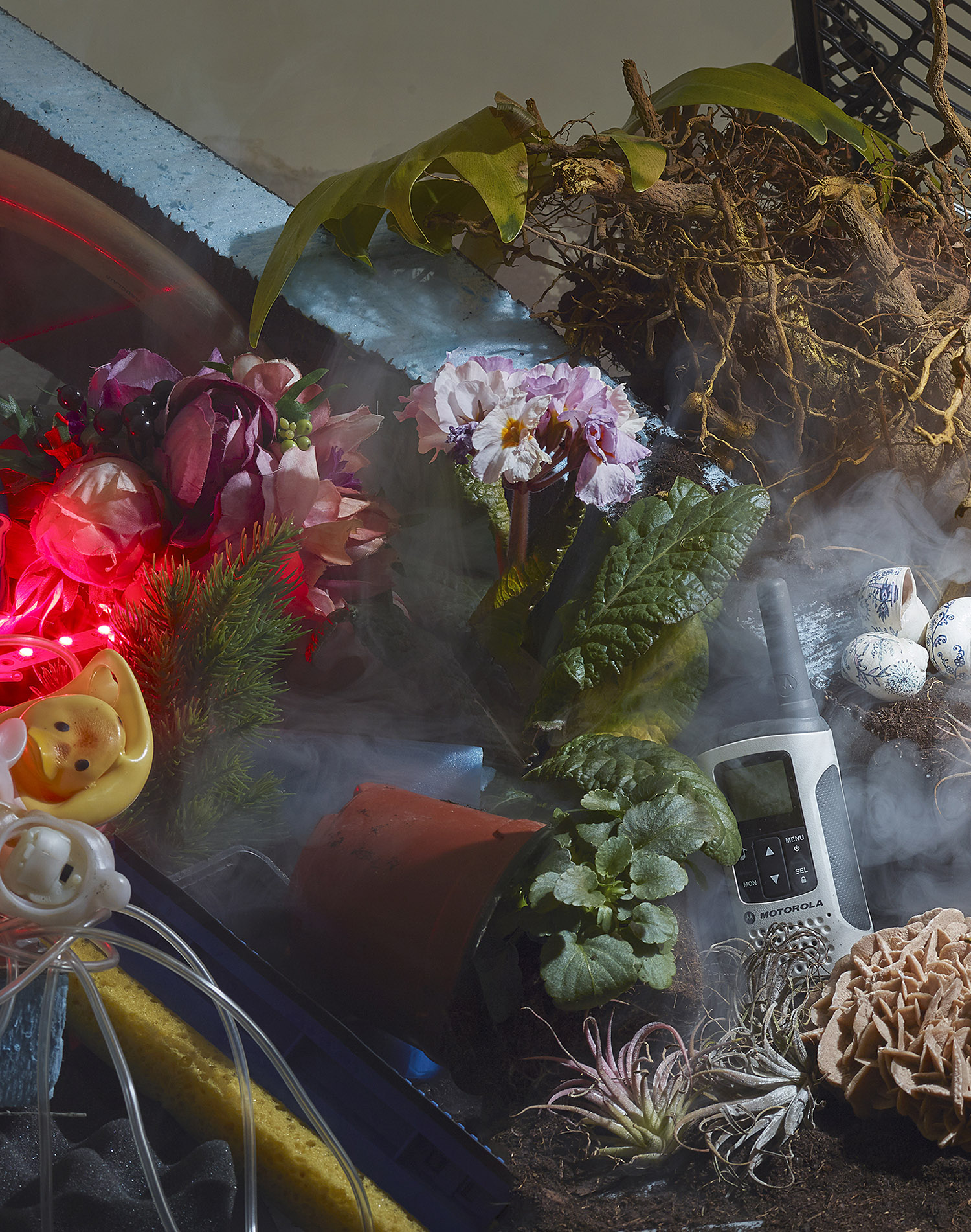 KMA photographer Daniel Schweizer photographs a sink full of flowers and a phone surrounded by smoke