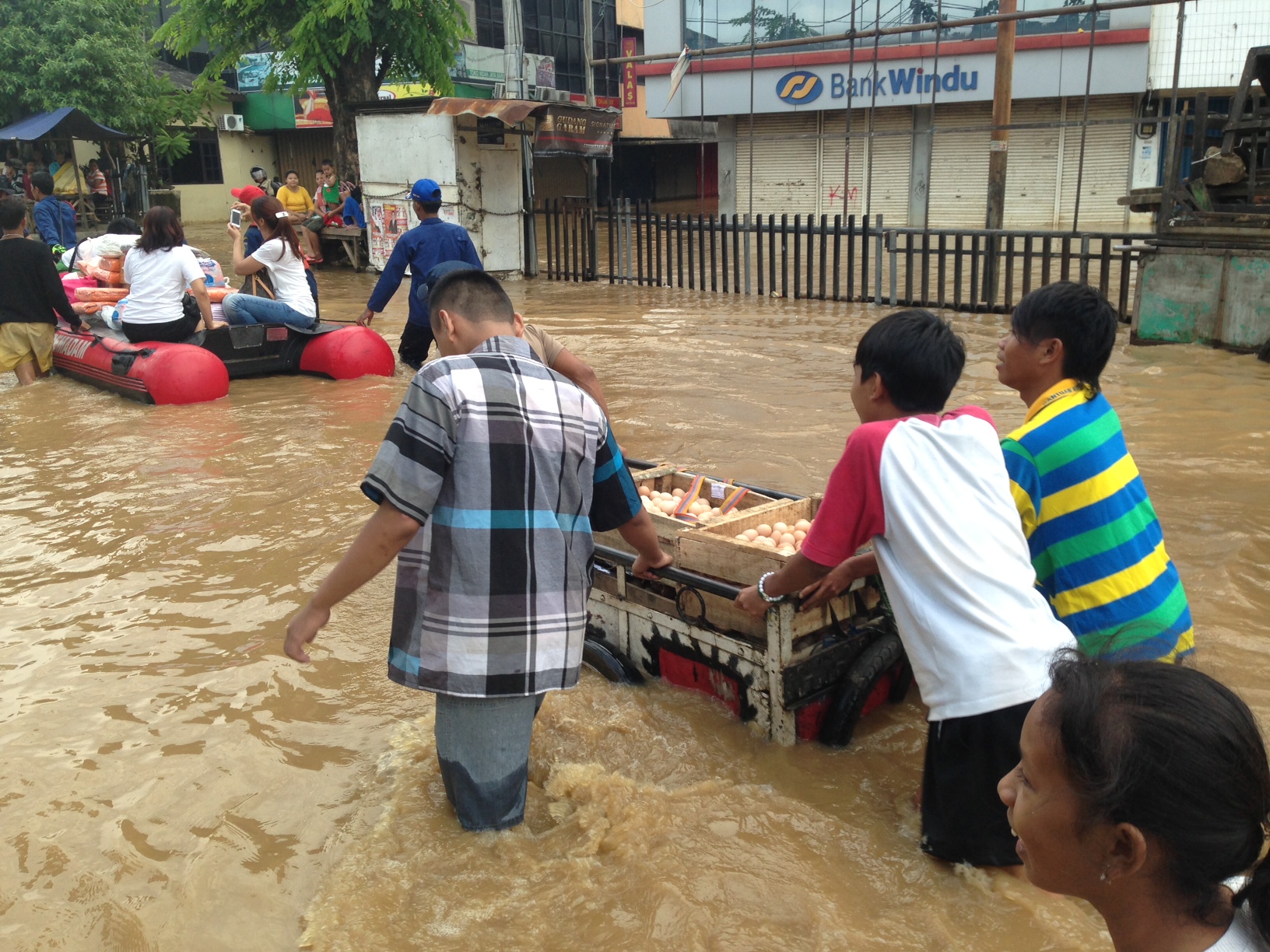 Residents in the Jatinegara District coordinate evacuations and help deliver emergency supplies during severe flooding.