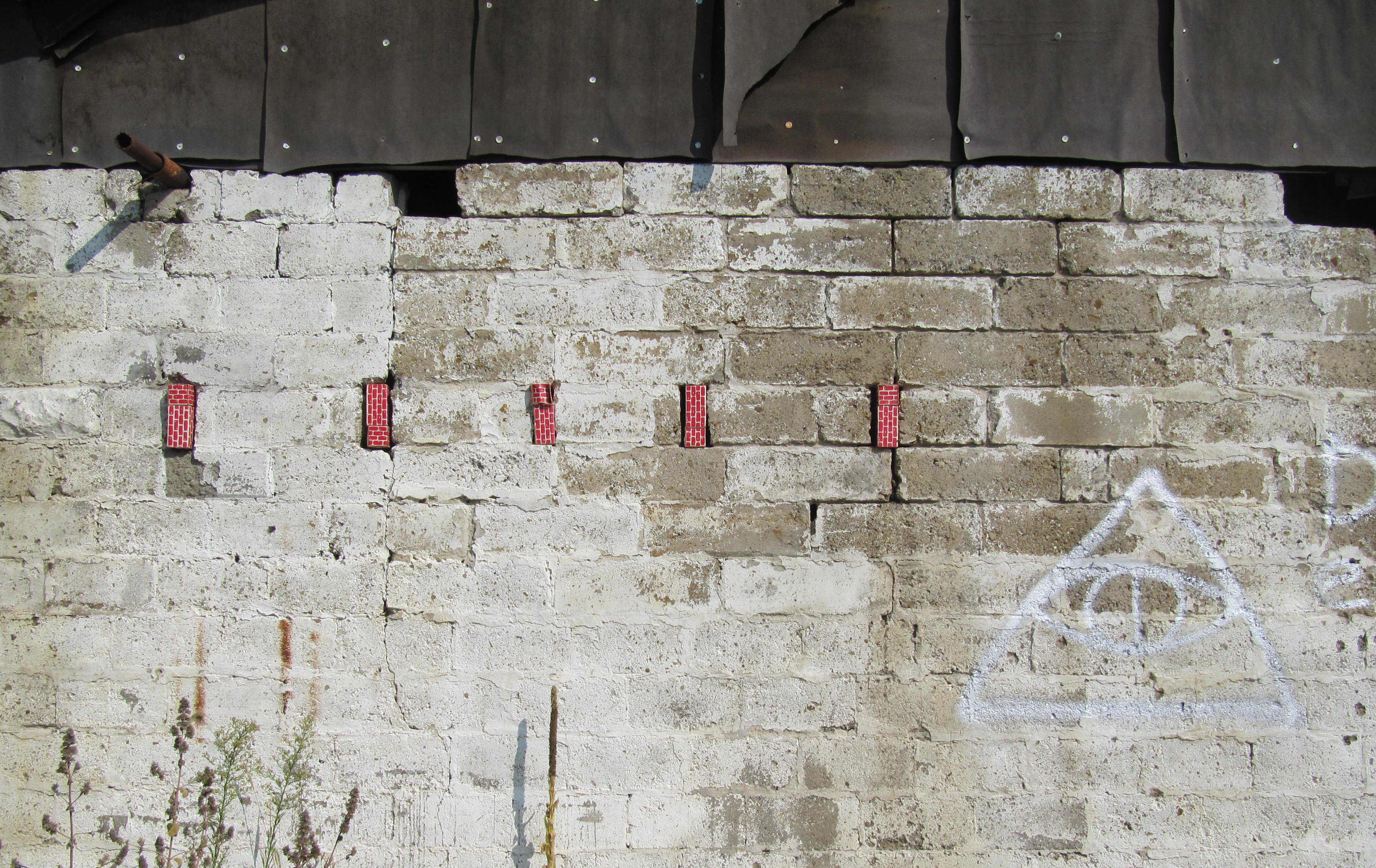 Real News, Fake Wall, 10 x 20 feet, cardboard bricks and found illuminati wall 