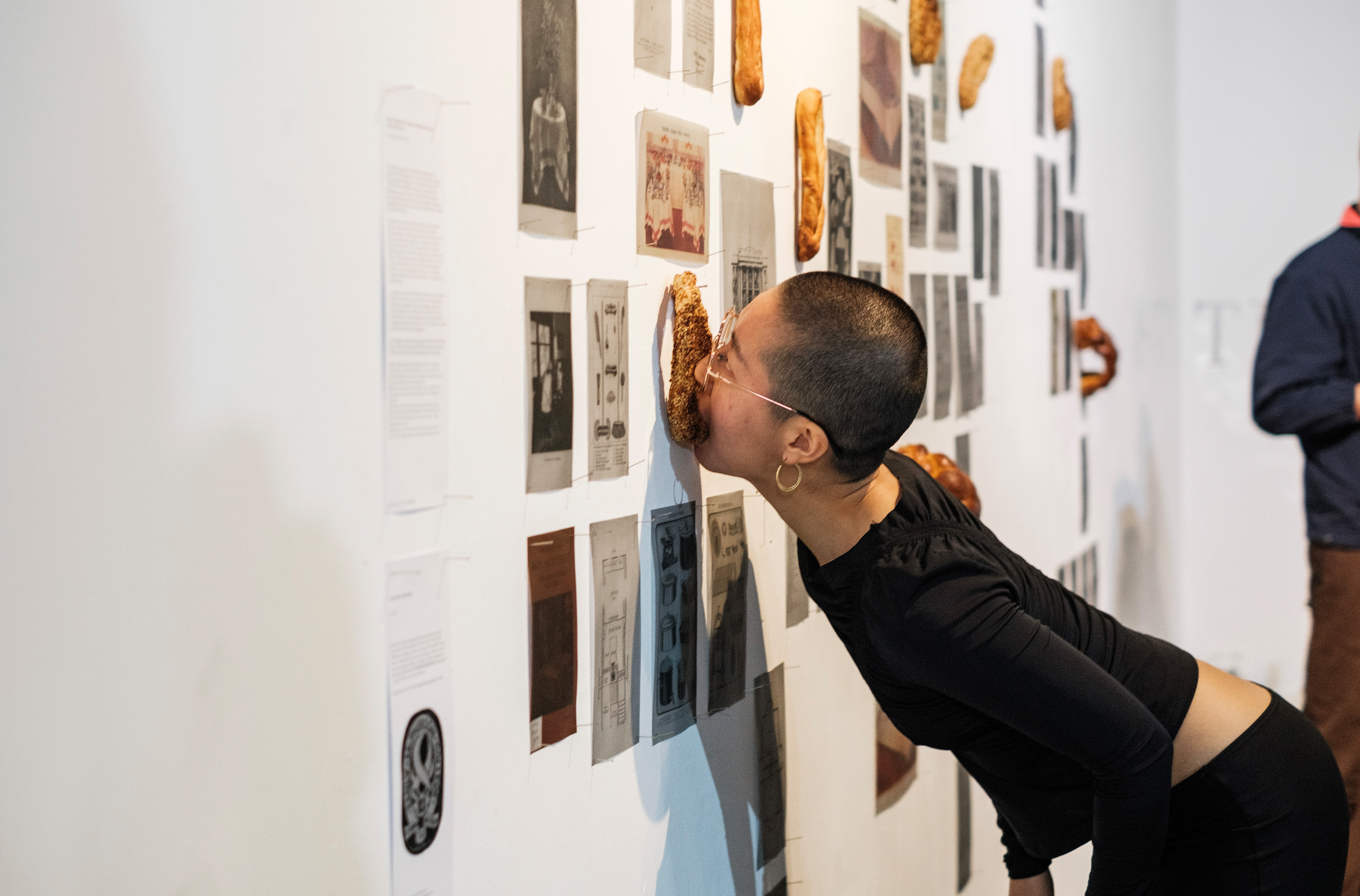 Bread is ripped from the walls by eager hands and mouths, transgressing taboos of both gallery and dining. Photography by Temitope Adesina