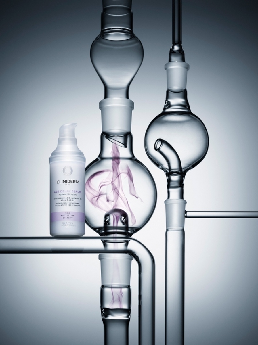 KMA photographer Mattias Nyhlin photographs white moisturizer bottle with glass bottles with a grey background for Cliniderm  