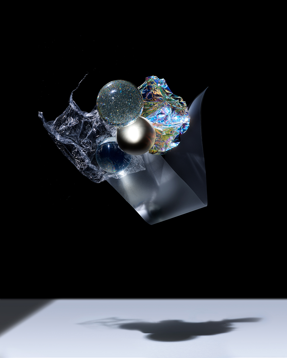 KMA photographer Isabelle Bonjean shoots glittery objects floating in the air with a black background