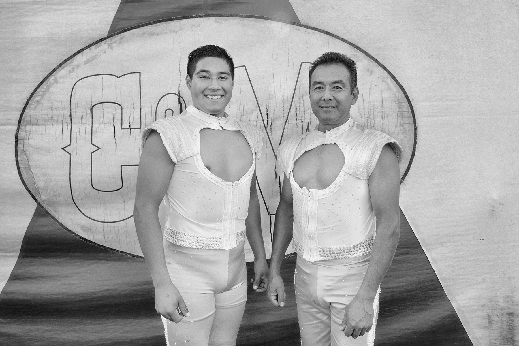 The Perez Duo–Romario and his father Mamo–pose for a portrait outside the tent. They present "The Wheel of Destiny".