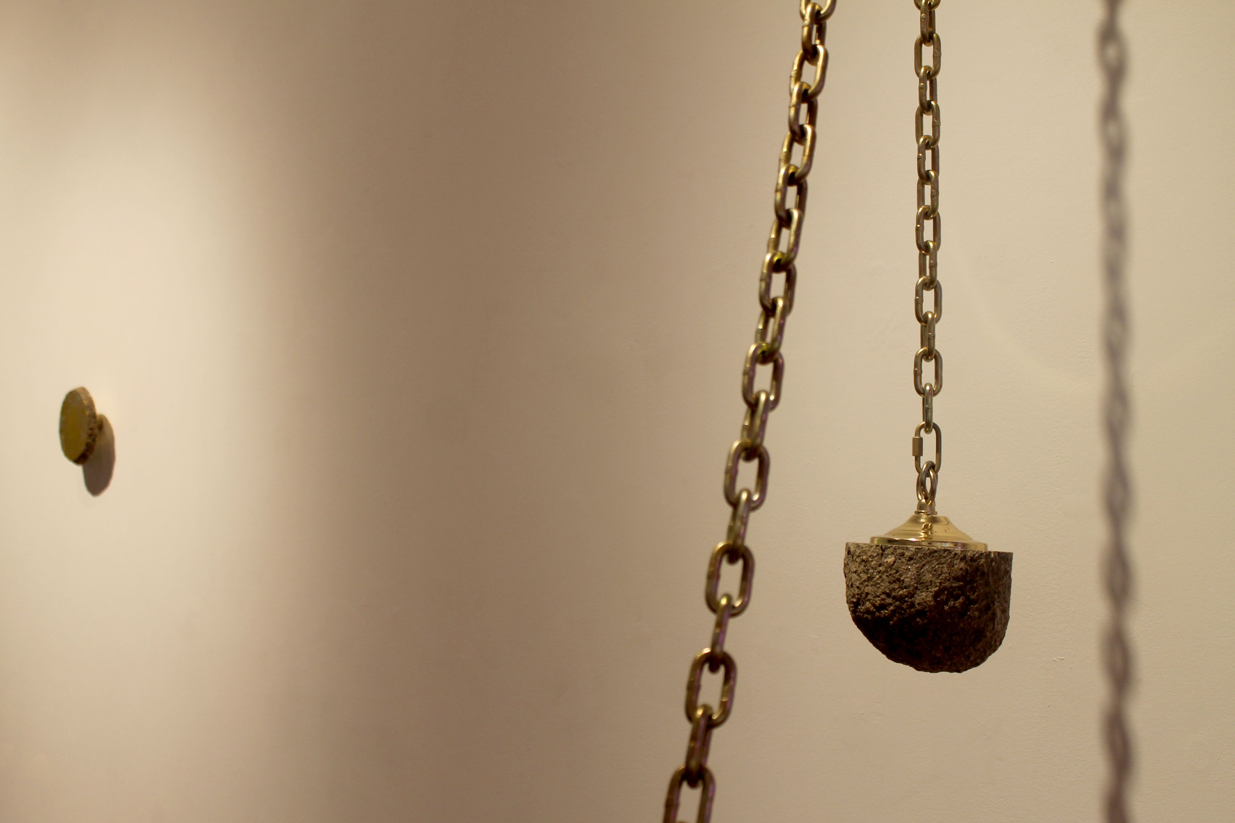 A Rock Knows When It's Been Stolen, sizes variable, 10 x 8.5 x 5 feet, brass, Iowan Glacial Erratic and chain