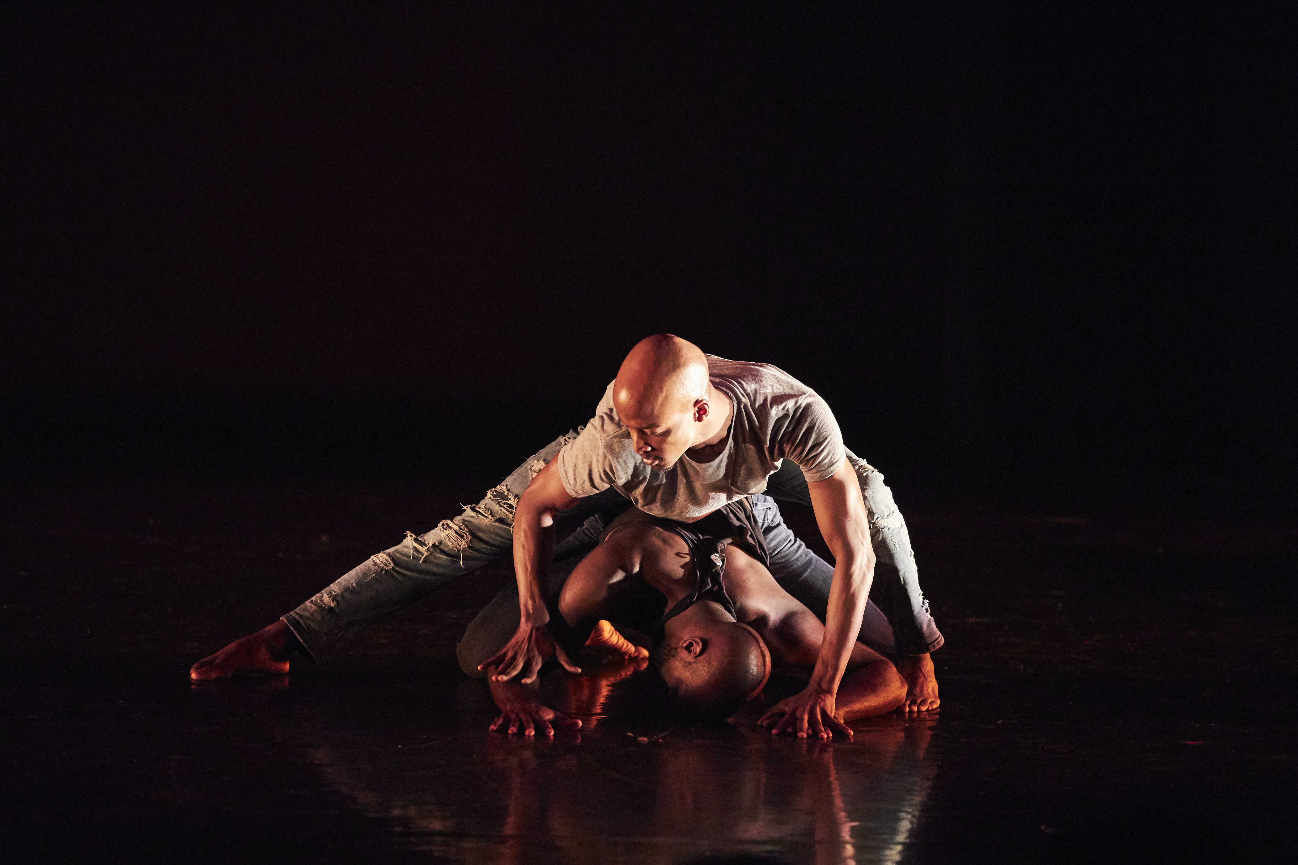 Image 5 of 6: Two young black men dancing crouched on the floor