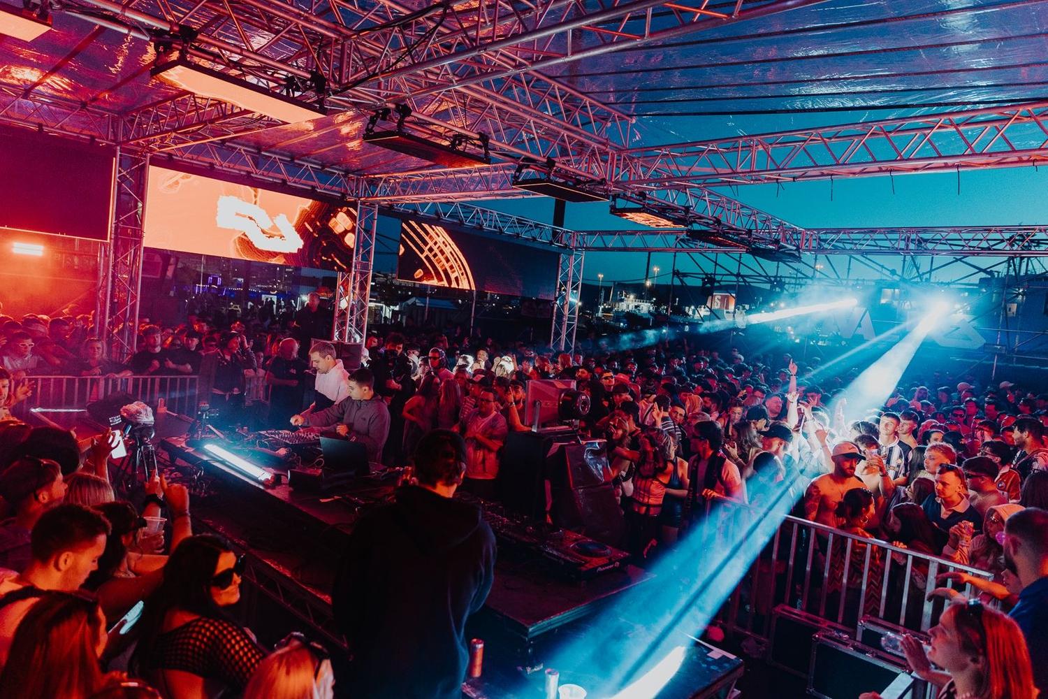 999999999 performing on the AVA x Resident Advisor The Dock stage at AVA Festival Belfast 2025 with crowd dancing under lights