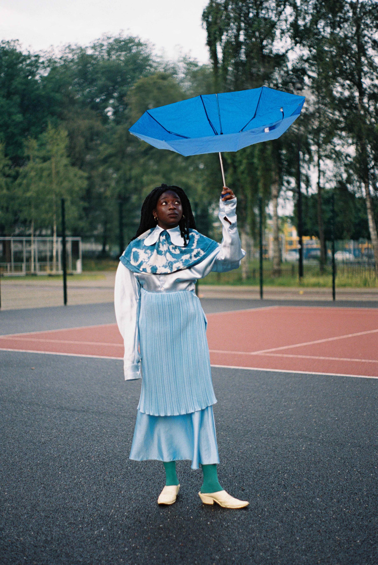 Model in Bijlmer, Amsterdam in blue holding umbrella
