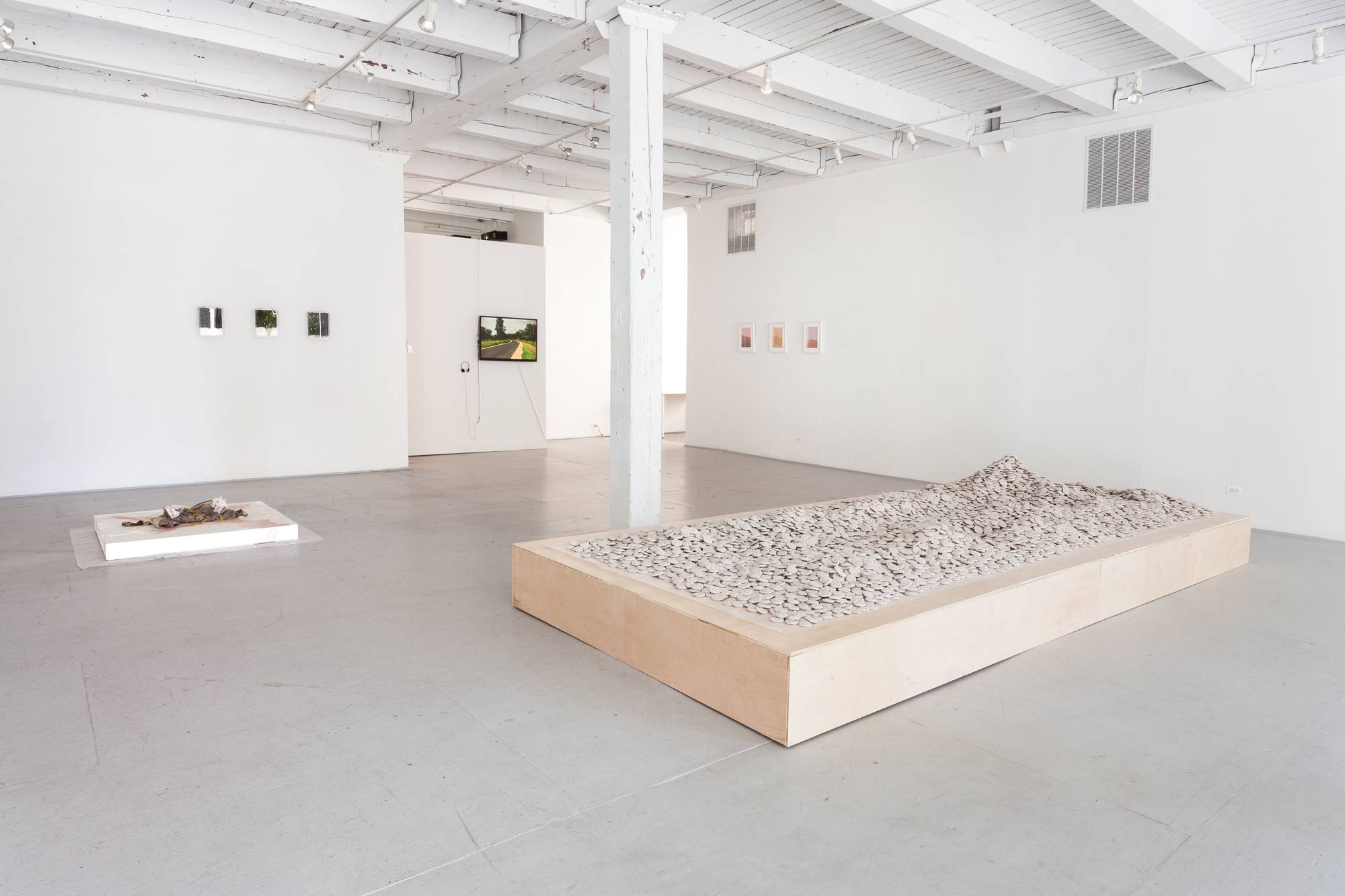 3/3 — 18,928 TOLL HOUSE COOKIES.The title references the average number/lifetime supply of cookies consumed by an American adult. This average equates to approximately one cookie a day between the ages of 18-72. Toll House cookies refers to the chocolate chip cookie, which Ruth Graves Wakefield invented in the 1930s, and continues to be the most popularly consumed cookie type in the United States.First presented in the exhibition Revolvers are Meant for Crocodile Skins at Chicago Artists Coalition in 2016 and later in the Women Made 20th Annual Open in 2017. Hand-built clay (approx. 1,500 lb.), wax paper, wood plinth.