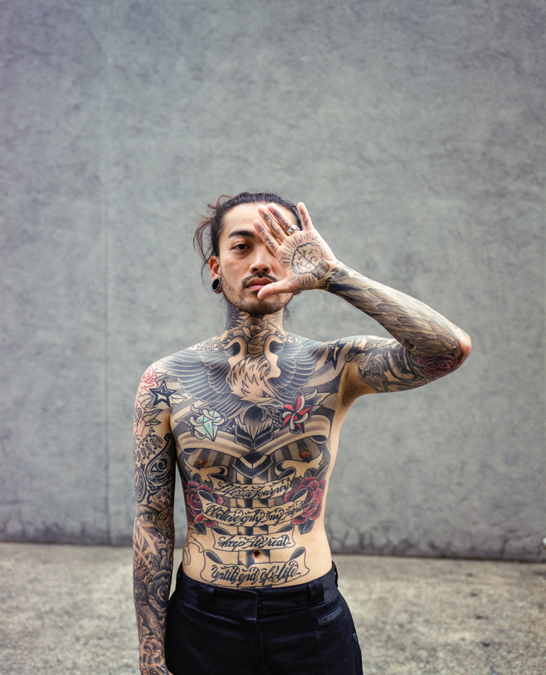 Toshio displaying his full body tattoo in Harajuku