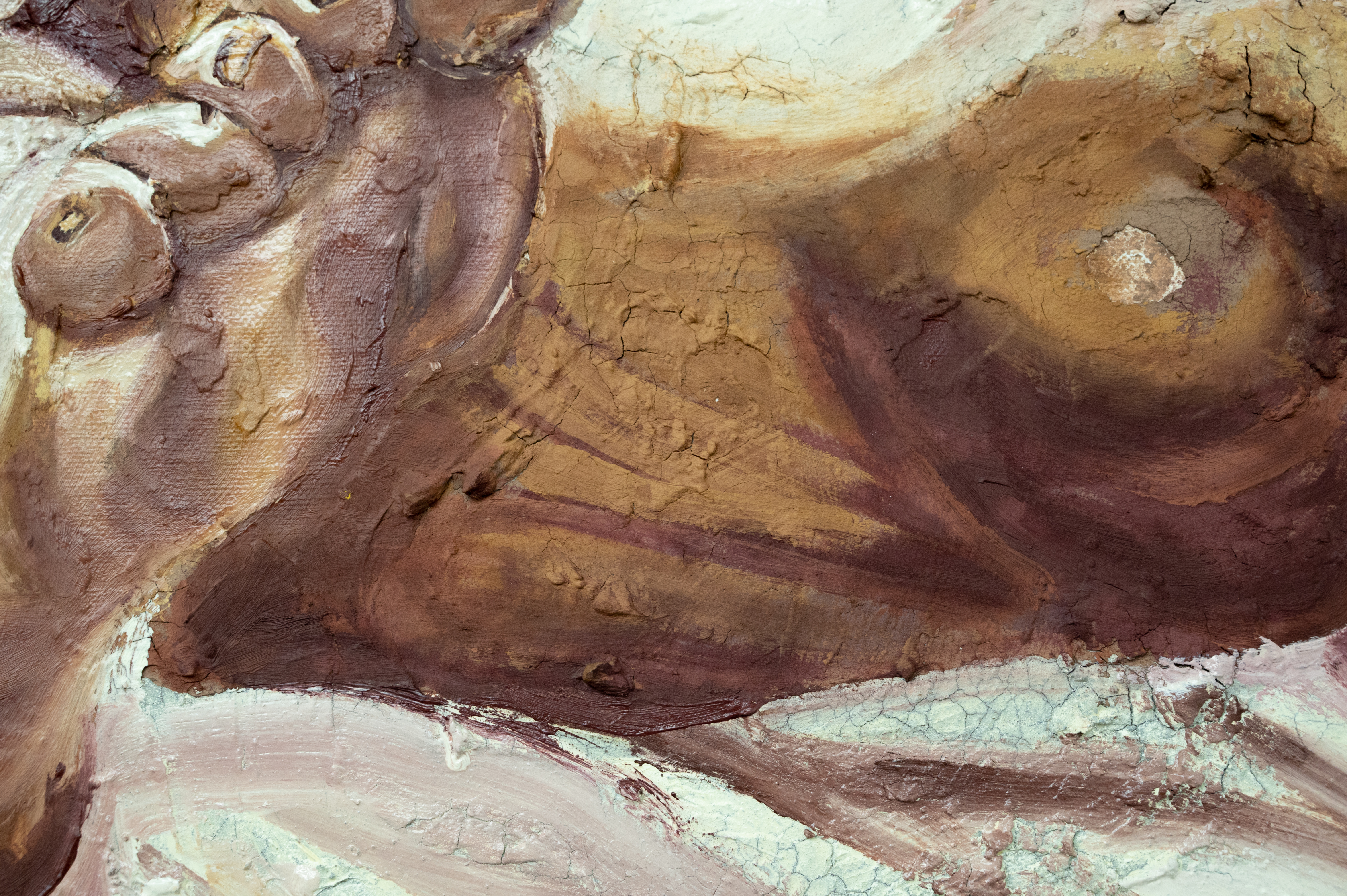 detail of artwork showing the feet made of clay, with cracked textures