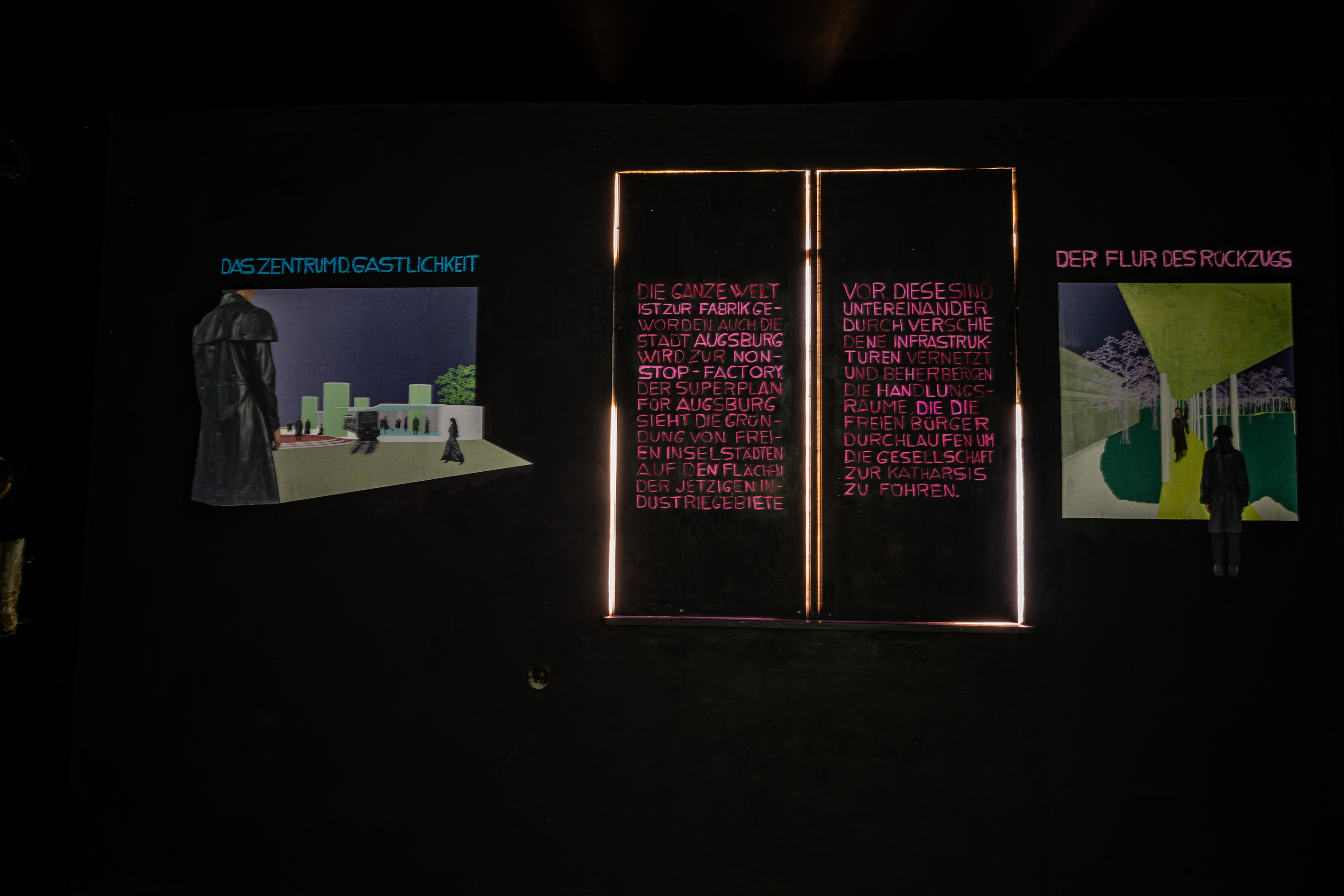 Bild 4 zu Die Welt als Fabrik: Eine schwarze Wand mit zwei Collagen. In der Mitte geschlossene Fensterl&auml;den auf denen in pinken Buchstaben ein Erkl&auml;rtext &uuml;ber die Welt als Fabrik steht.