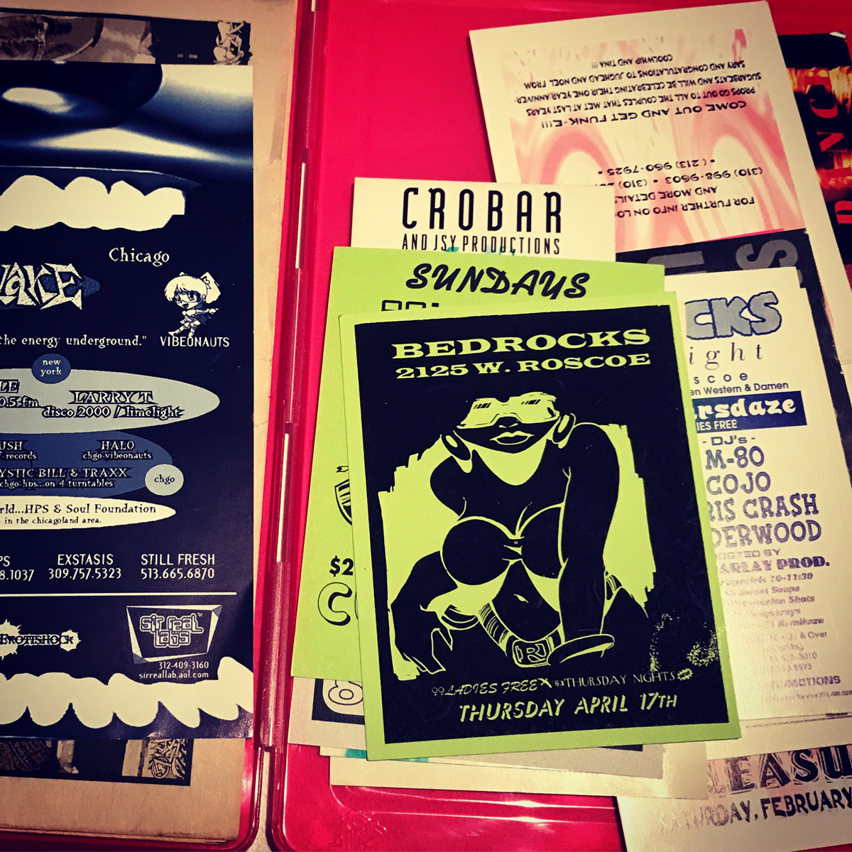 Image: A collection of ephemeral materials from Chicago House music events over the years, as collected and catalogued by The Blackivists archivist collective as part of the Chicago Black Social Culture Map: Early Chicago House Edition event in spring and summer 2019. The top flyer says "BEDROCKS" 2125 W. Roscoe, Ladies Free Thursday Nights, Thursday, April 17th. Photo courtesy of Stacie Williams.
