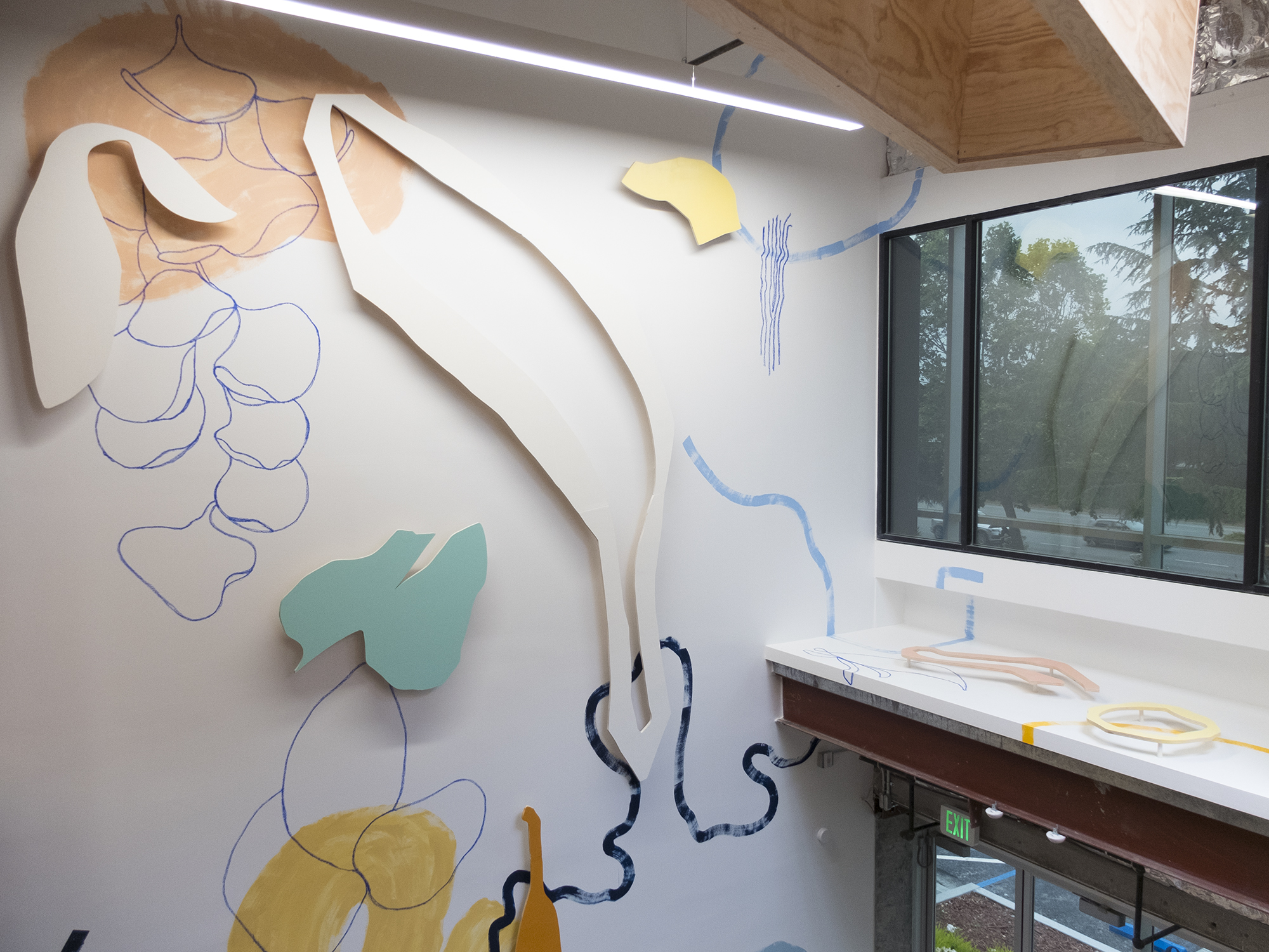 Wide view shot of mural with cut plywood shapes in modern office building, by Jimmy Mezei.
