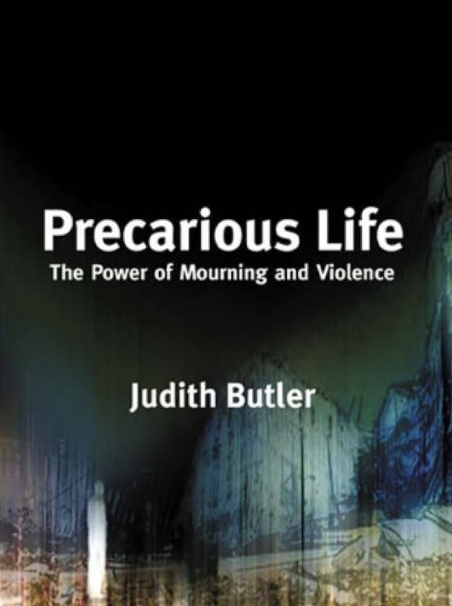 the book cover for 'precarious life' by judith butler. the book is black with blueish, greyish, and greenish abstract shapes which rise from the bottom. the title of the book is written in white letters on the top. a siloutte of a ghostly figure is on the bottom left in a white transparent shape.