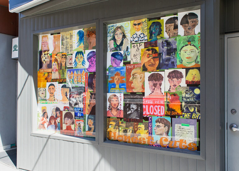 A photo of The New Gallery's storefront, in the windows all of the paintings from the "Honest Cuts" Projects are hung in the form of a collage.