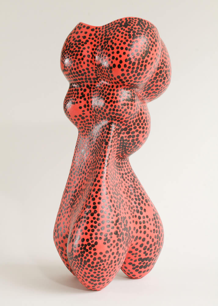 A red ceramic sculpture with black spots