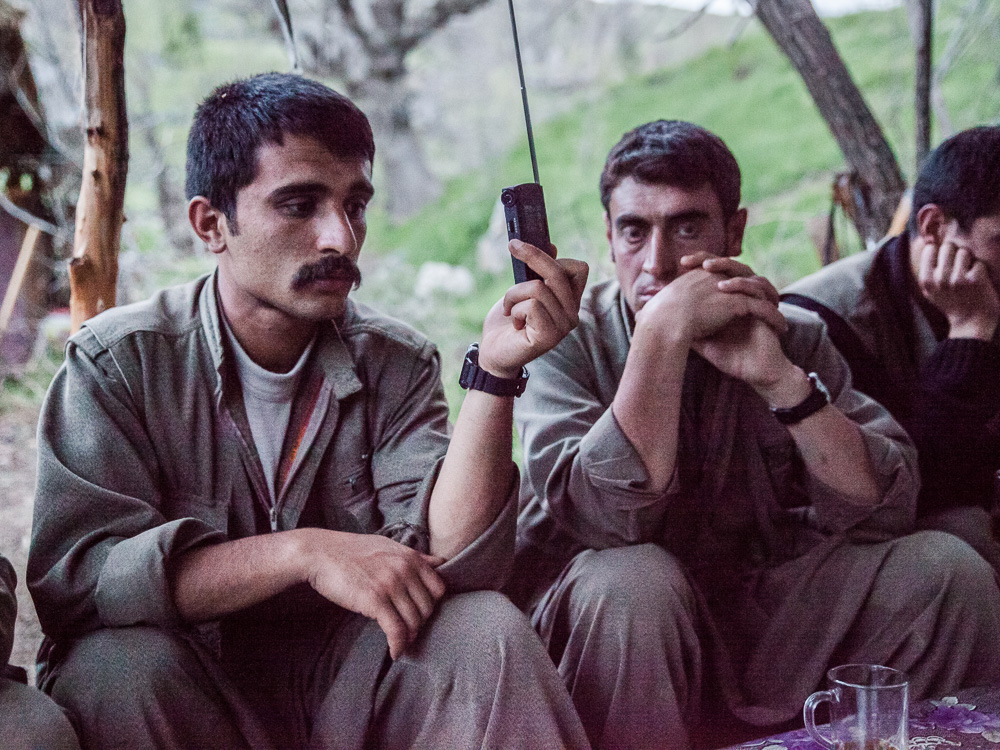 Qandil, Kurdistan. Apr&egrave;s le repas du soir, l'unit&eacute; &eacute;coute les informations &agrave; la radio.  C'est un des rares moments d'ouverture sur le monde ext&eacute;rieur, et chacun &eacute;coute attentivement les nouvelles pour ensuite les commenter. Certains campements peuvent parfois disposer d'une t&eacute;l&eacute;.