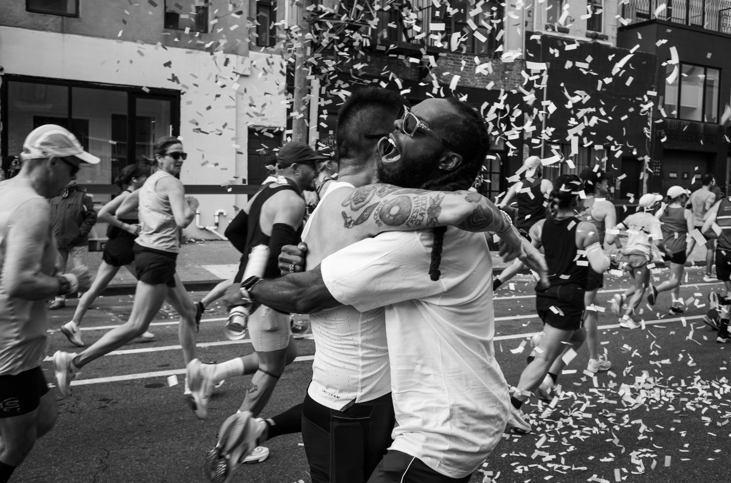 Running coach Jerry Francois embraces a runner along Bedford Ave. during the New York City Marathon. Nov. 5, 2023.