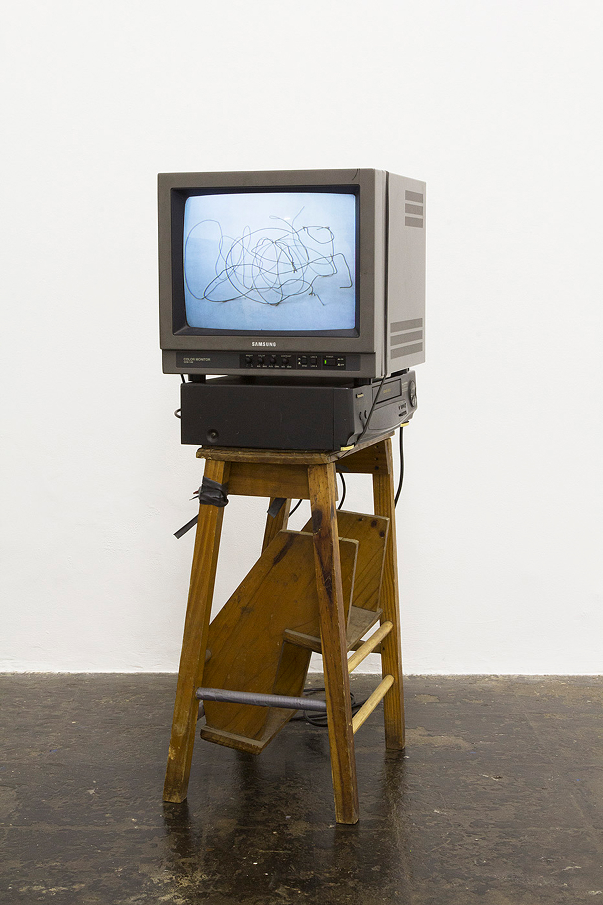 Jared Ginsburg, Rehearsal with Wire (2013) | Video, VHS player, monitor, step-ladder, rubber and clamp, 4:00:00, 102 x 42 x 35 cm