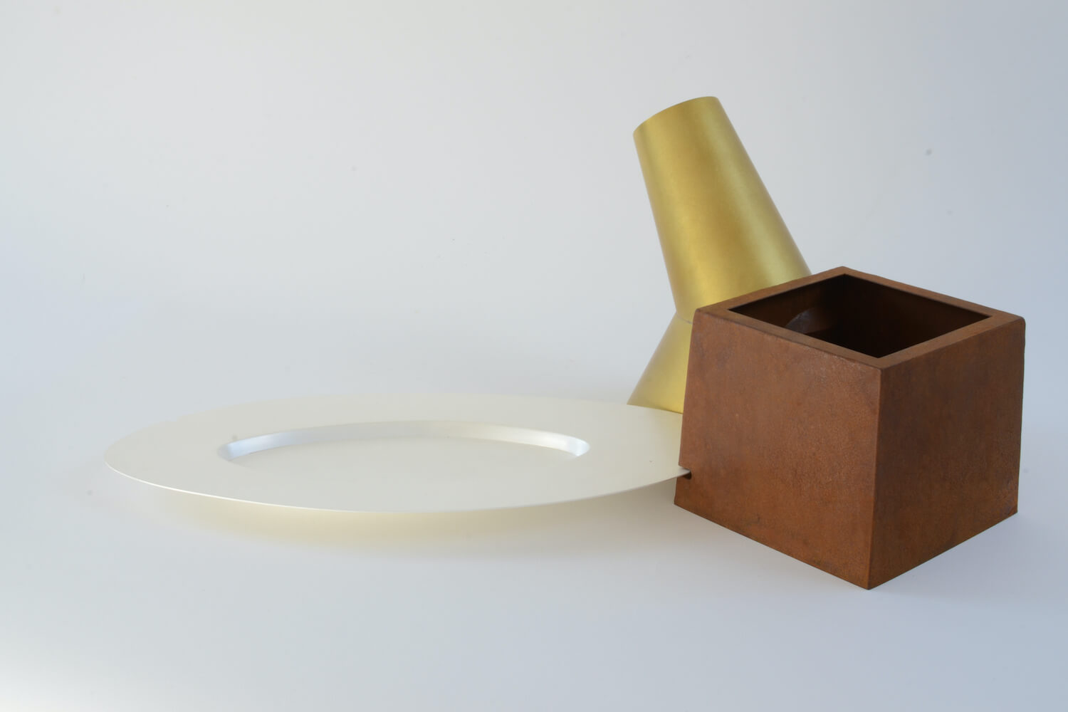 A sculpture made of two different metals and a plate