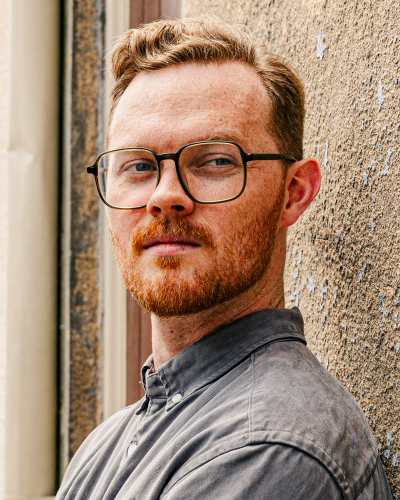 James May, Visiting Researcher (Brown Univ) James May (b. 1994, Pittsburgh, PA) is a composer, improviser, teacher, and writer. His work explores unfurling, fragile spaces, generating unpredictable systems in which performers can dwell. He combines approaches such as improvisation environments, live electronics, notated scores, field recordings, extended vocal technique, and text, often inspired by the natural world or other art forms&mdash;especially film photography and literature. James is a member of Versipel New Music (New Orleans), has published writing in Sound American and RT&Eacute; Culture, and was a 2024 Ucross Artist in Residence. He has collaborated on performances and recordings with Versipel, Apply Triangle, Hypercube, Chamber Choir Ireland and Paul Hillier, Birdfoot Festival, New Music on the Bayou, Stephanie Lamprea, Will Yager, Jamie Monck, the San Francisco Choral Artists, and Longleash.&nbsp;James was one of 12 recipients of the 2018-19 George J. Mitchell Scholarship, funding an MA in Experimental Sound Practice at University College Cork; prior, he earned an MM in Composition from the University of Louisville, and a BMus in Theory & Composition and a BA in English from The College of Wooster.︎︎︎ jamesmaycomposer.com