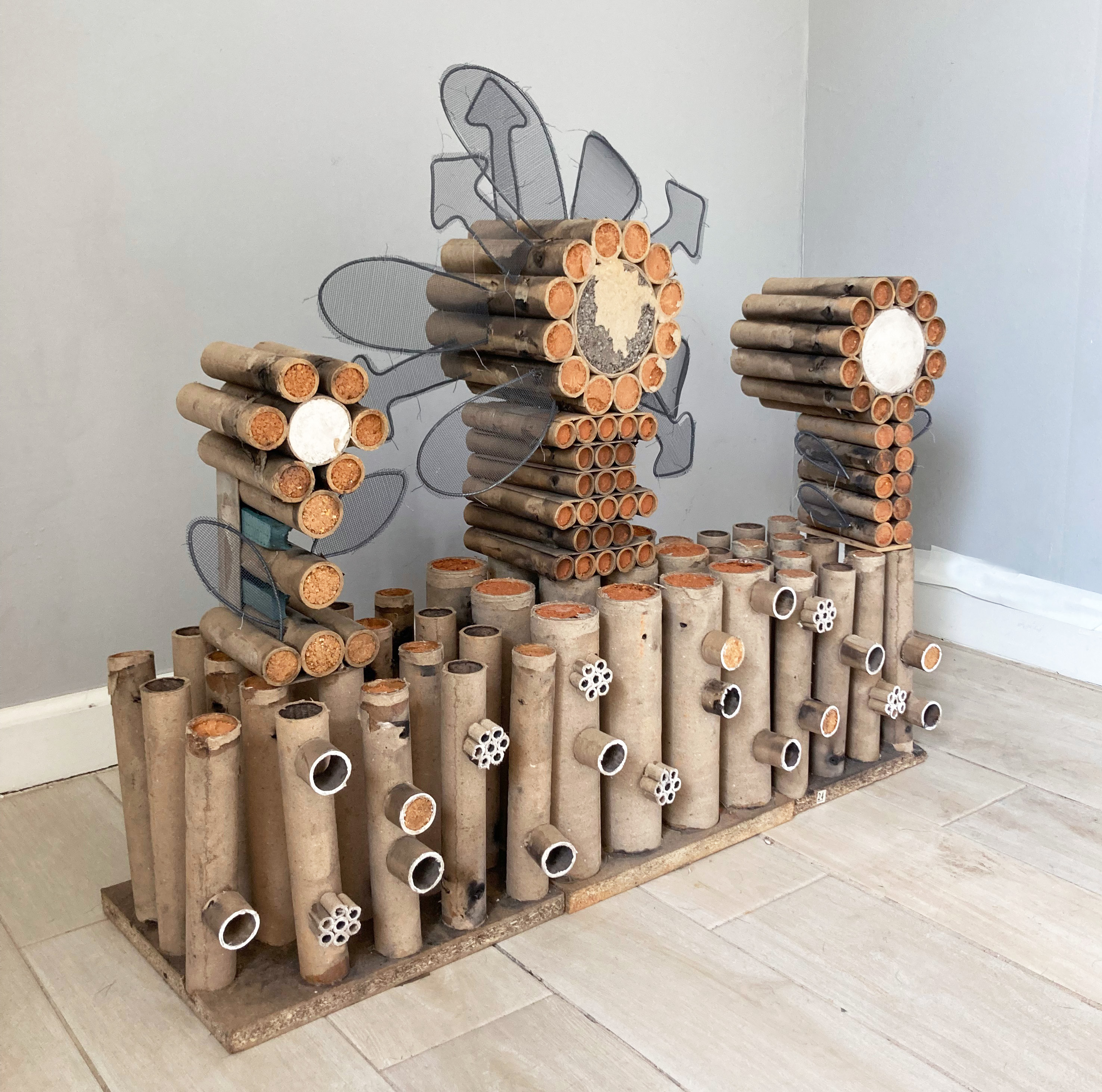 Earth Tower, 2023, Found firework refuse, wire, aluminum mesh, wood, 32" x 10" x 28"