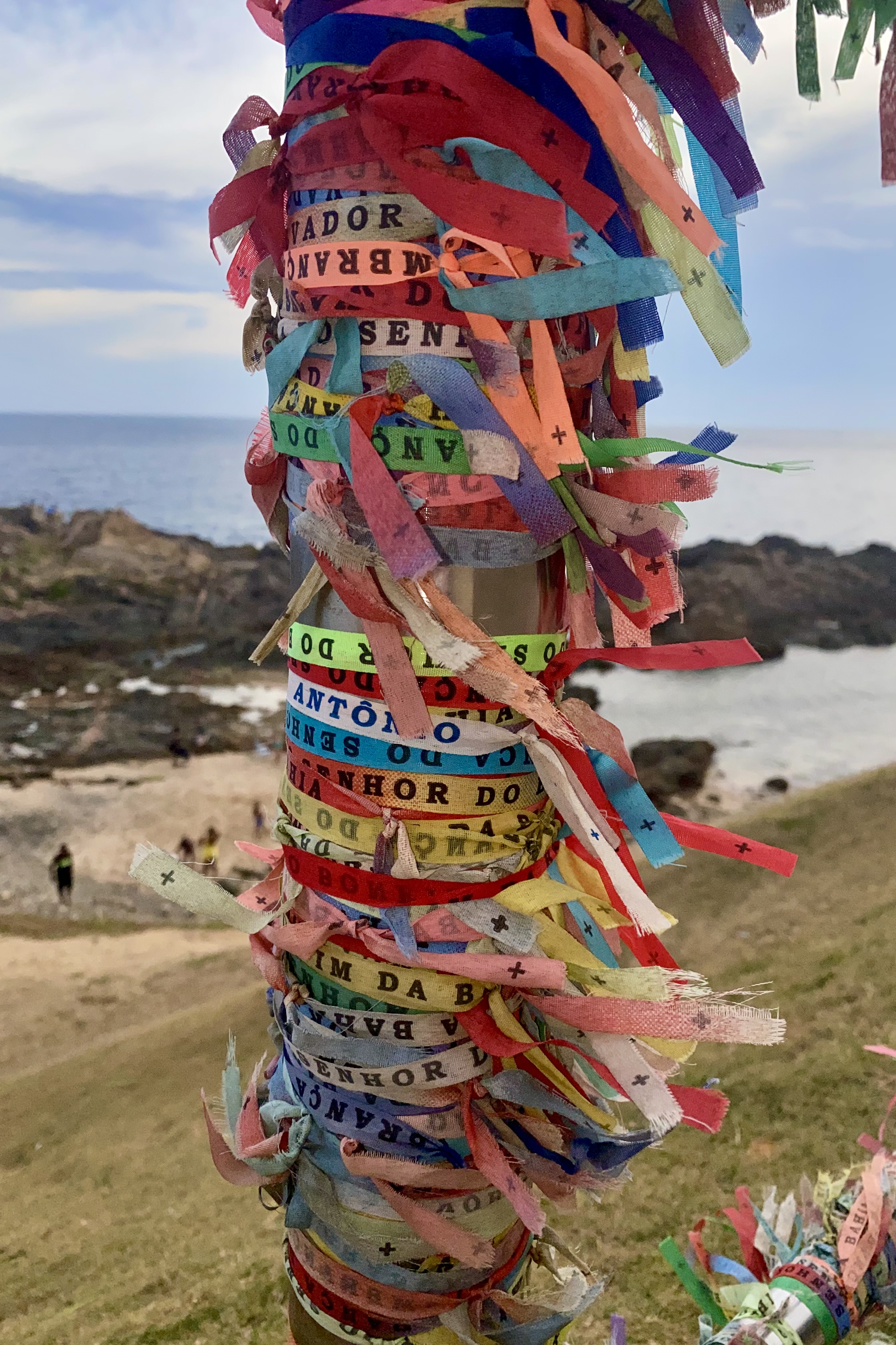 Colorful Bonfim wish bracelets, Lembrança do Senhor do Bonfim da Bahia, are tied onto a railing in Salvador, Brazil, symbolizing faith, luck, and tradition.