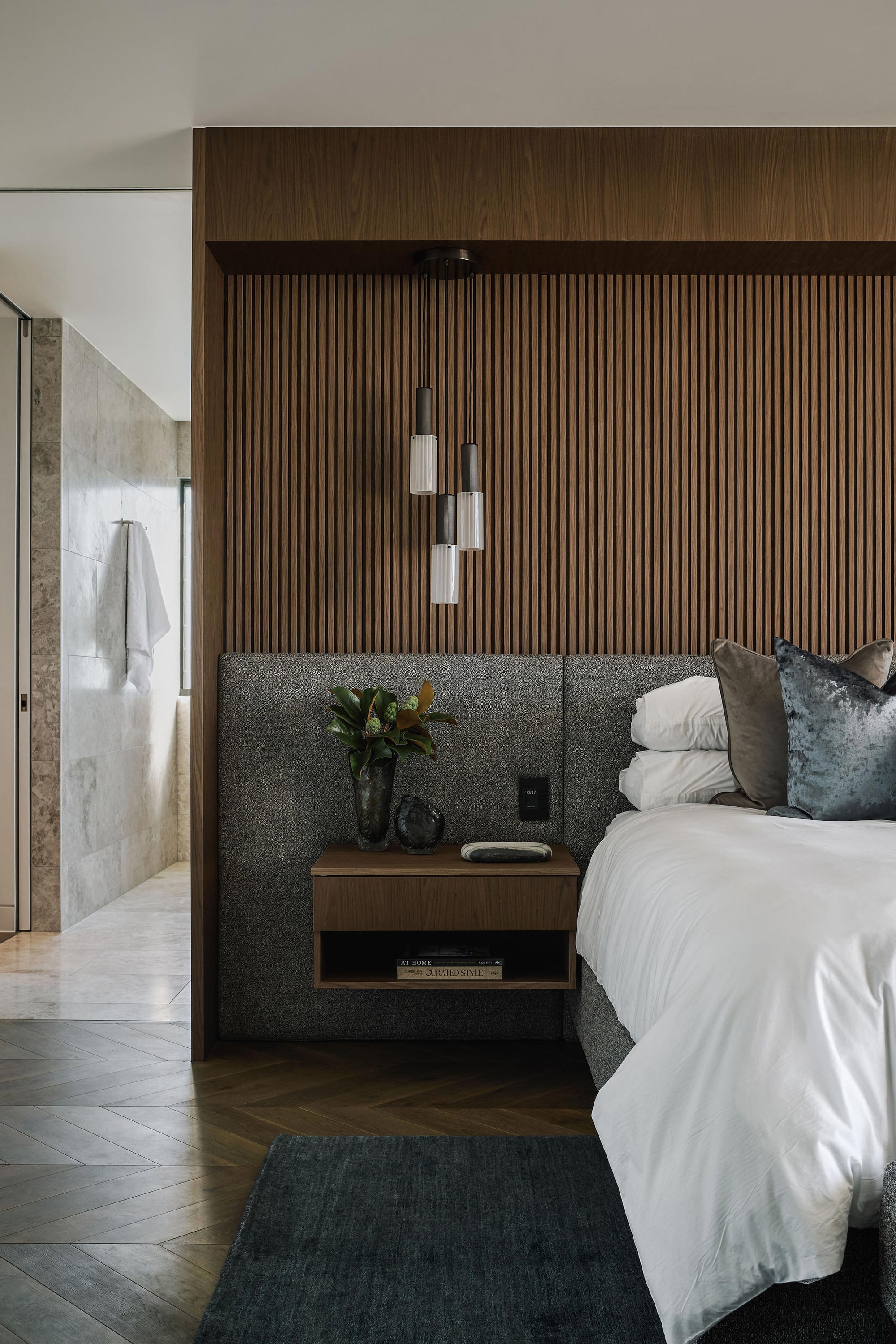 A modern bedroom featuring wooden accents and a neatly made bed, creating a warm and inviting atmosphere.