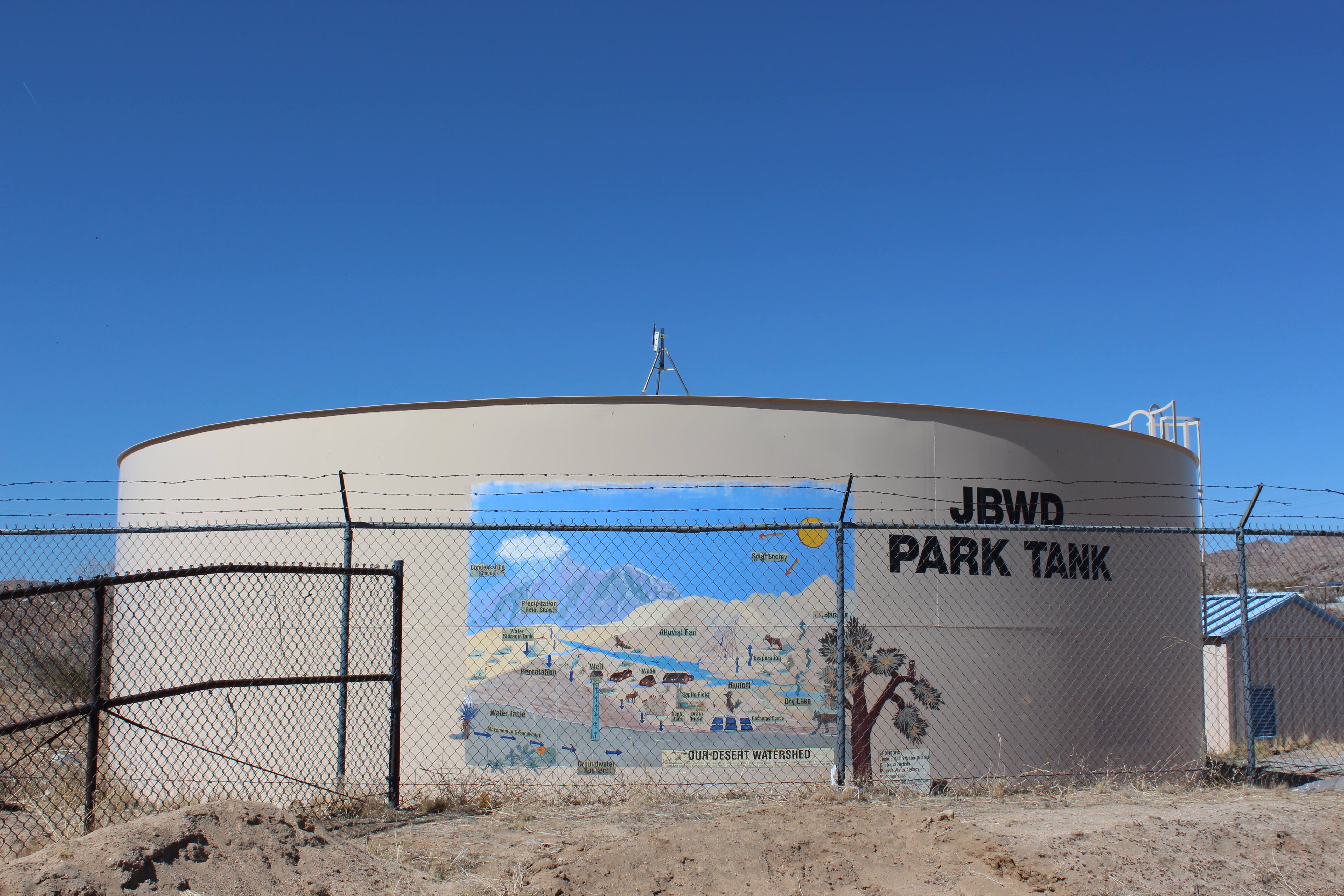 Water tank reading "JBWD PARK TANK" with really charming mural of desert water cycle