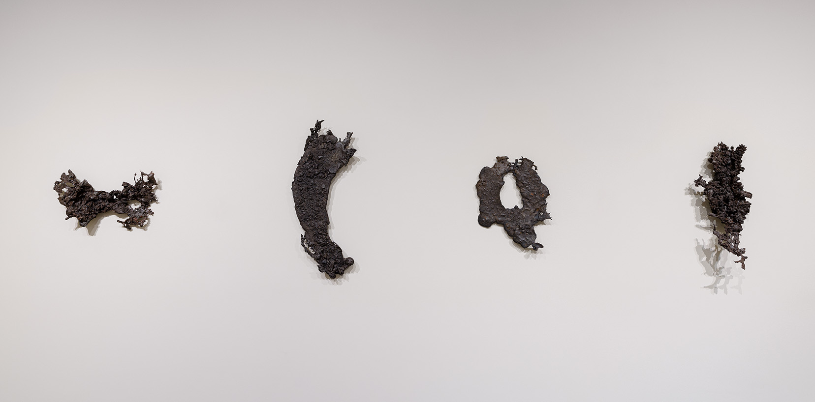 (From left to right) Athena LaTocha, "Mesabi #1," 2019. Cast iron, 17 1/4 x 13 3/4 x 2 3/8 inches; "Mesabi #4," 2019. Cast iron, 28 3/4 x 13 3/4 x 3 1/8 inches; "Mesabi #6," 2019. Cast iron, 11 1/4 x 19 3/4 x 3 3/8 inches; "Mesabi #7," 2019. Cast iron, 22 1/2 x 10 3/4 x 6 1/2 inches. Photo by Etienne Frossard.