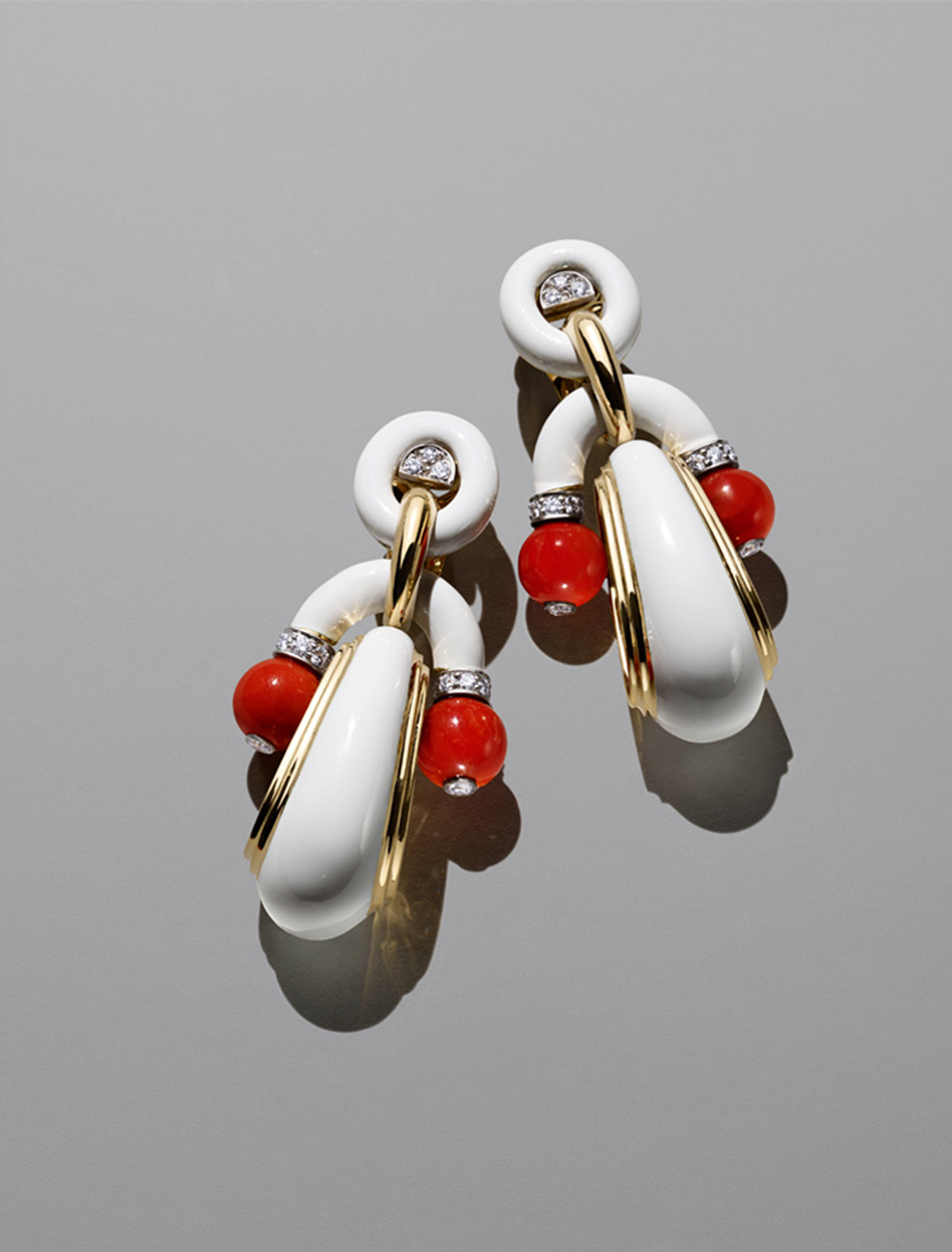 KMA stylist Sara Wacksman designs set for a photo of bright white and red earrings on a gray background for Bergdorf Goodman