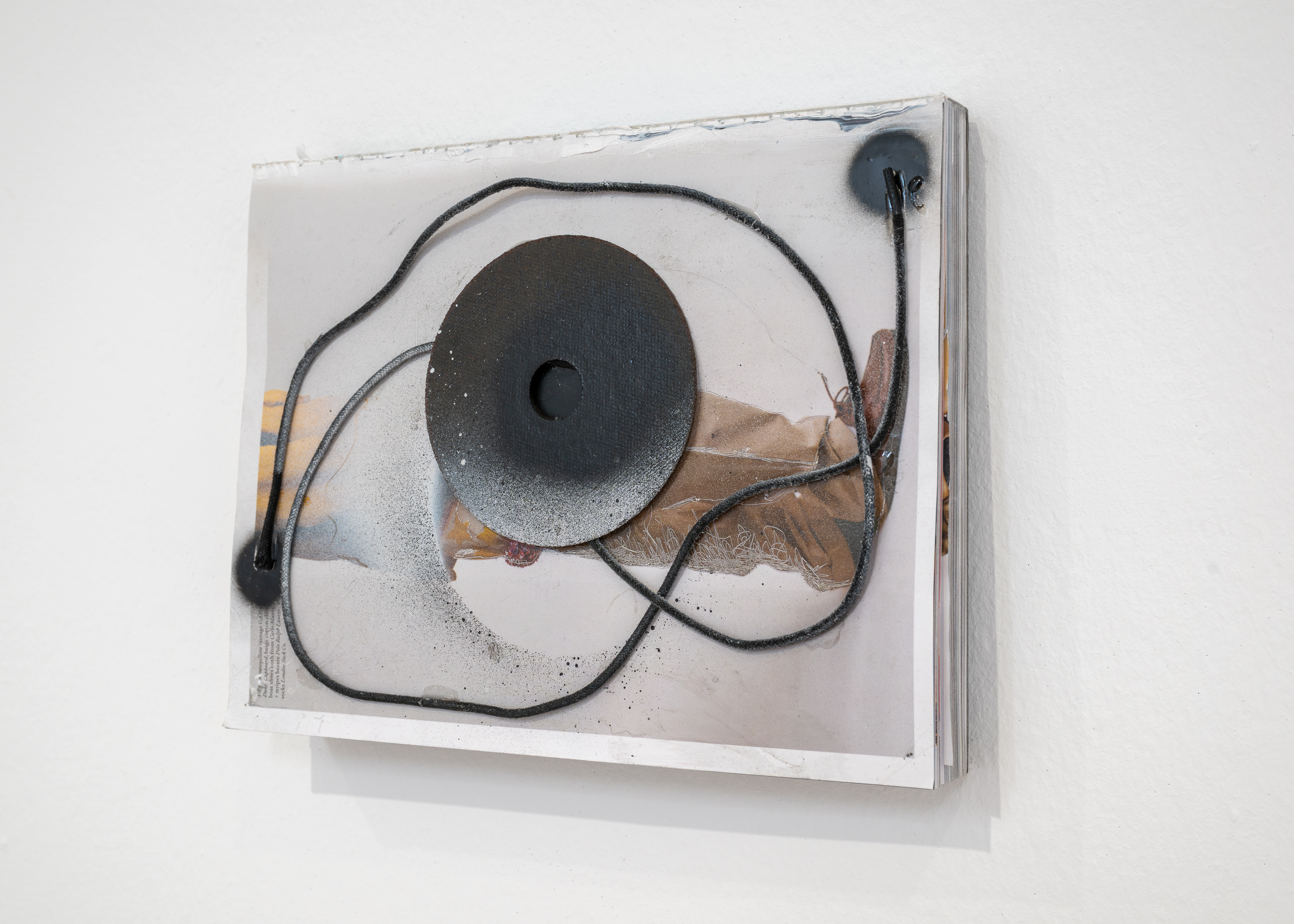 Overflow I, 2025, magazine, shoelaces, circular saw blade, spray paint, steel plate, 29.7 x 3.5 x 23.2 cm