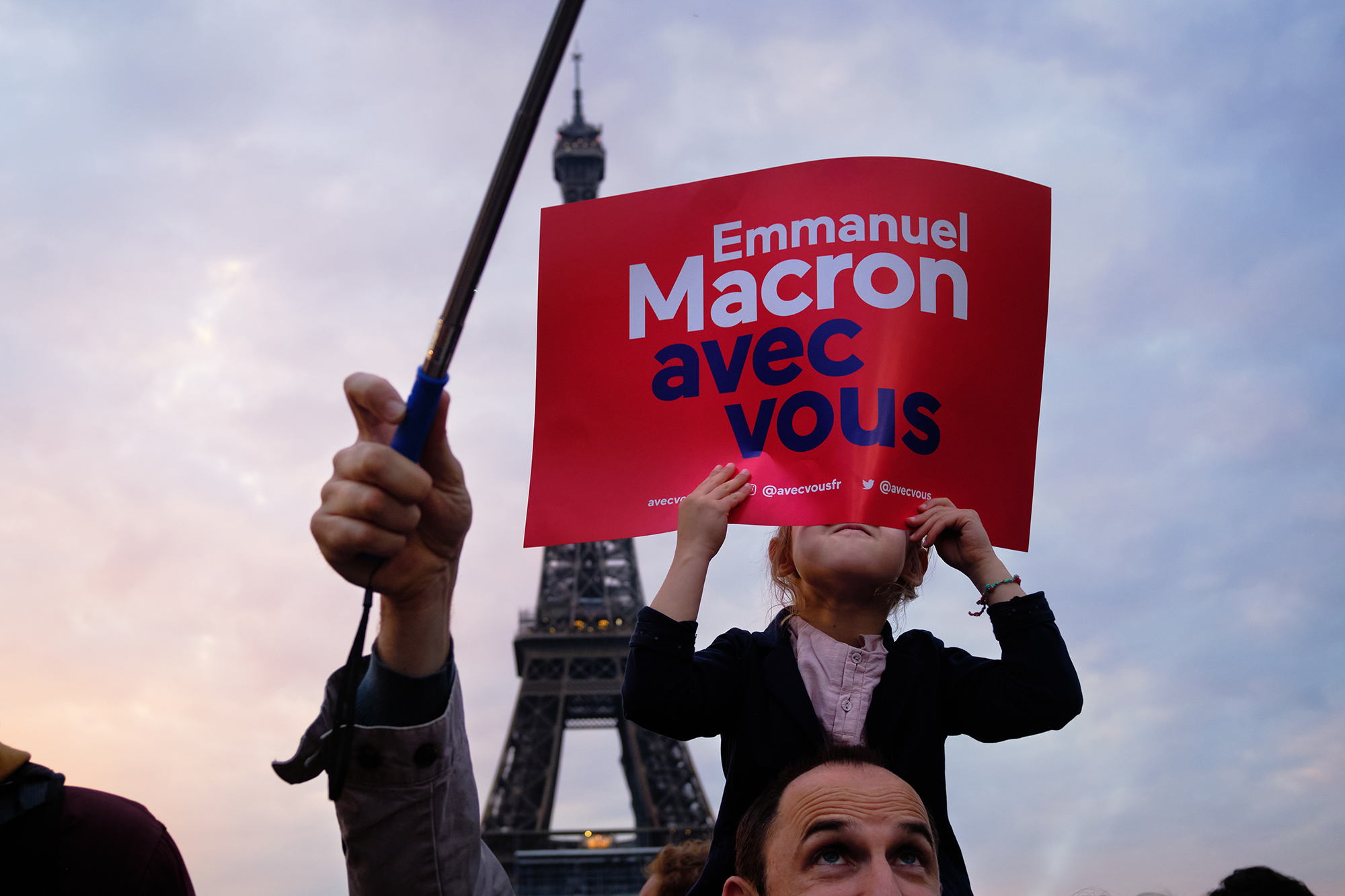 Philippe-Sarfati-reportage-photography-photographer-street-documentary-photojournalism-photojournalist-paris-france-eiffel-tower-champ-de-mars-macron-rassemblement-gathering-presidential-election-kid-hiding-avec-vous-shoulders-father-eyes-selfie-stick