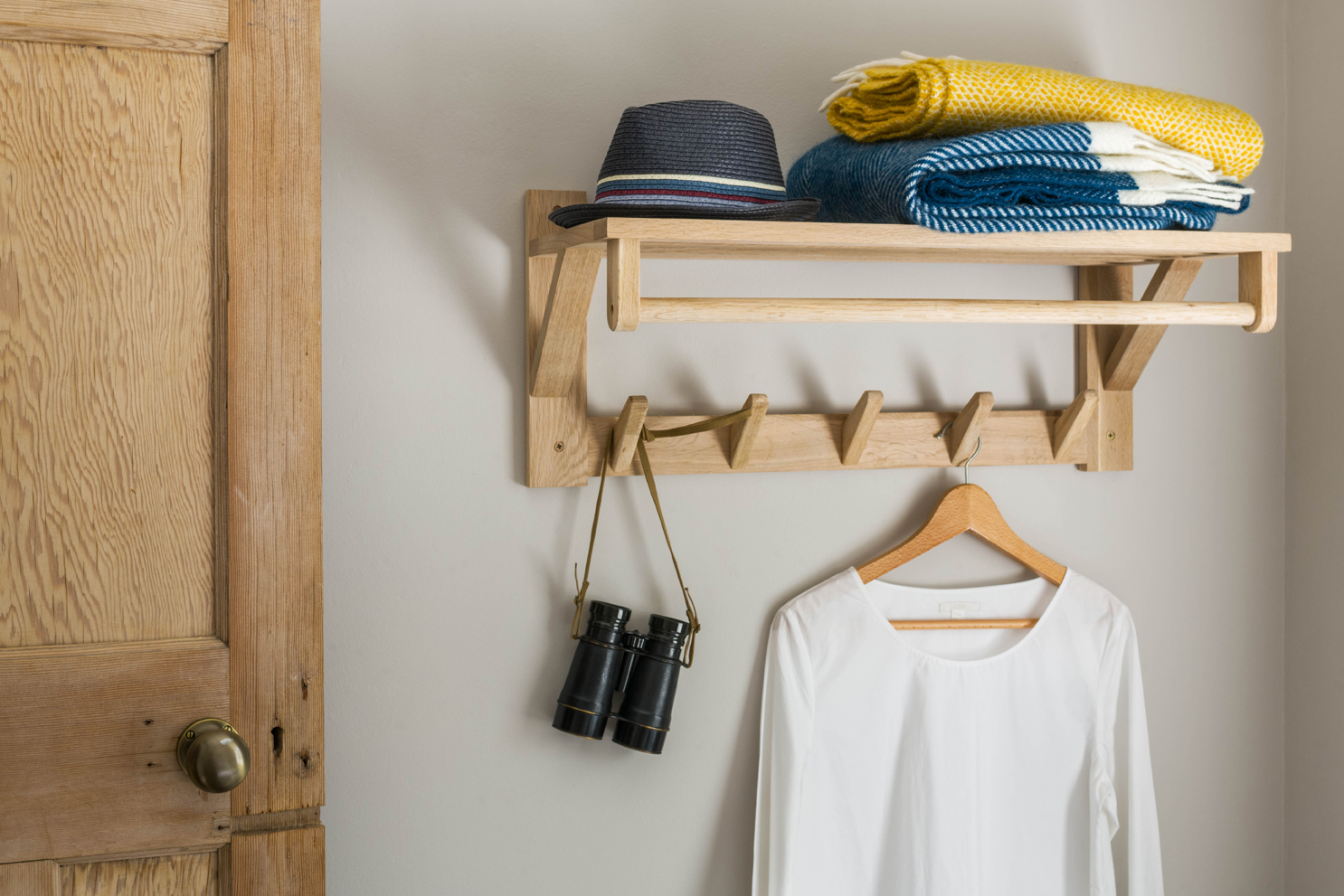 Close up of wooden clothes wall hook holding textiles. Showed as part of slideshow.