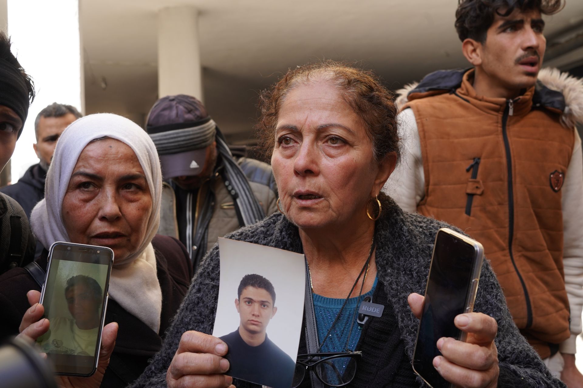 Woman shows photographs of her missing son.