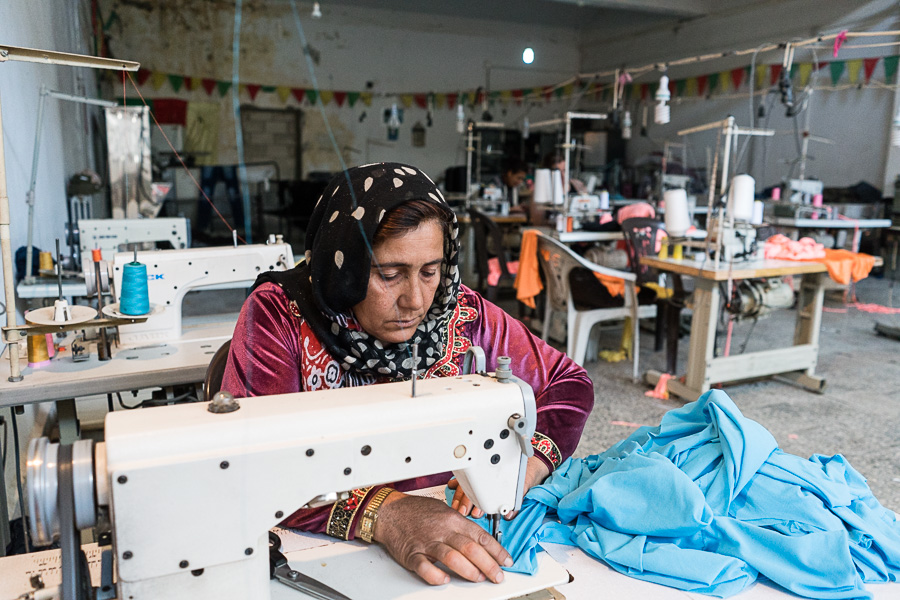 Kobane, avril 2018. Hadla. &laquo;&nbsp;Je travaille ici depuis un mois. Je voulais gagner de l'argent pour mes enfants. Une femme de notre quartier connaissait cet endroit, elle m'en a parl&eacute;.  Apr&egrave;s l'attaque de daesh, nous sommes all&eacute;s en Turquie en tant que r&eacute;fugi&eacute;s, j'ai travaill&eacute; dans les champs. Puis nous sommes revenus. Mais avant de partir de Kobane, j'&eacute;tais couturi&egrave;re.&nbsp;&raquo; Coop&eacute;rative textile ouverte par le mouvement des femmes, le Kongra Star. A lire : http://www.kedistan.net/2018/05/08/kobane-cooperatives-outil-emancipation-femmes/