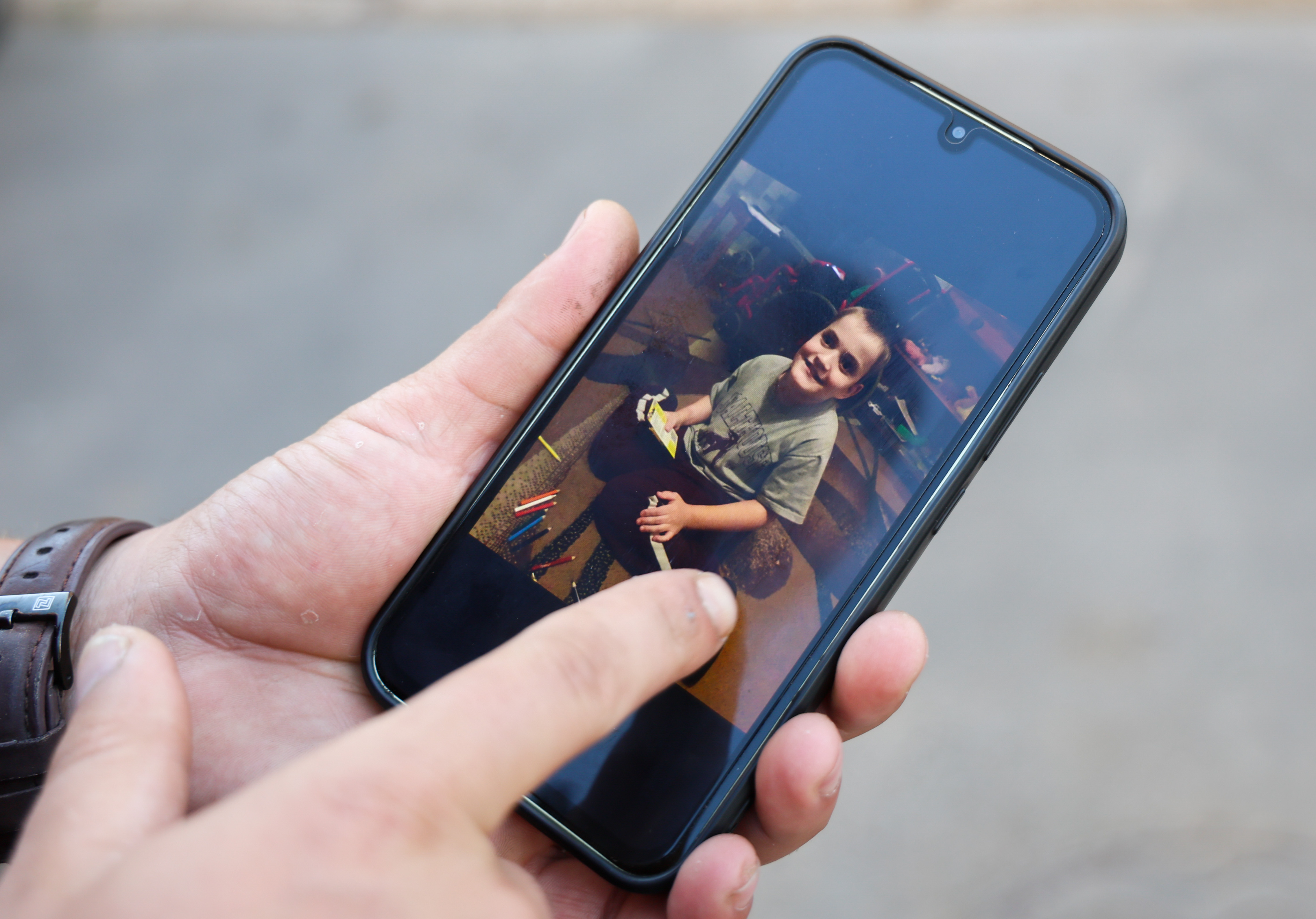 Petro Yenyushin shows a photo of his younger brother Gosha on his phone, taken shortly before he was taken from Oleshky.