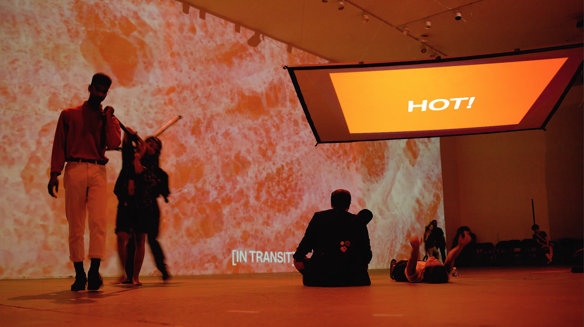 "Hotter than July; I Just Might Burn You in August" performance documentation, at Icebox Project Space. A large warehouse space bathed in red light.