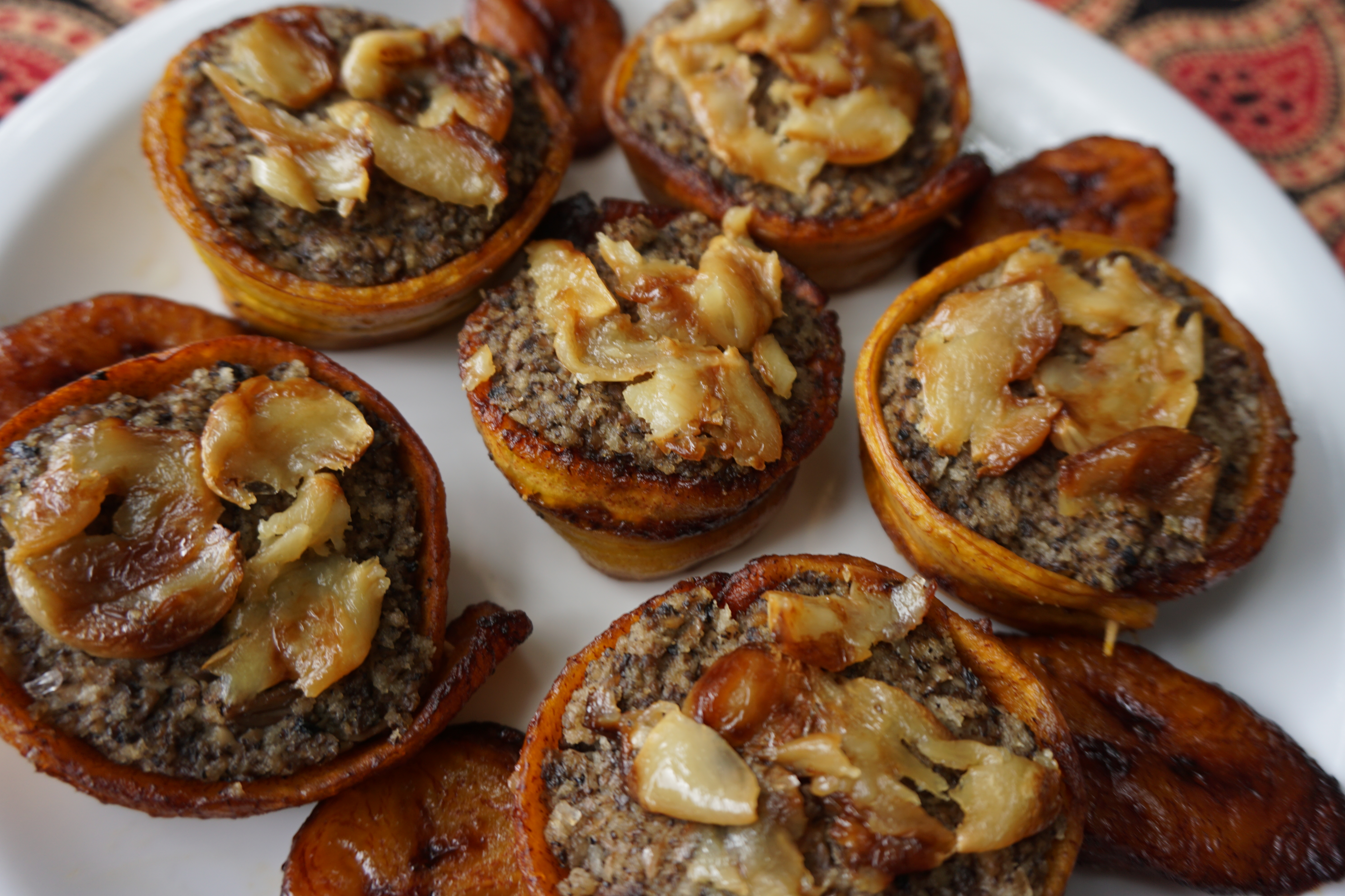 Mushroom Piononos with duxelle, a fried strip of sweet plantain, & topped with roasted garlic